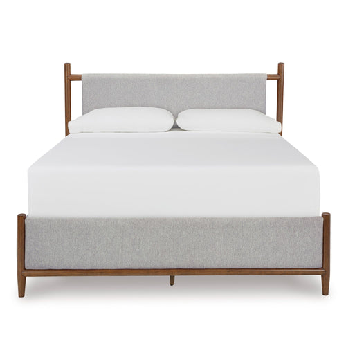 Signature Design by Ashley Lyncott upholstered panel bed with a padded headboard and sleek wood frame in a modern bedroom setting.