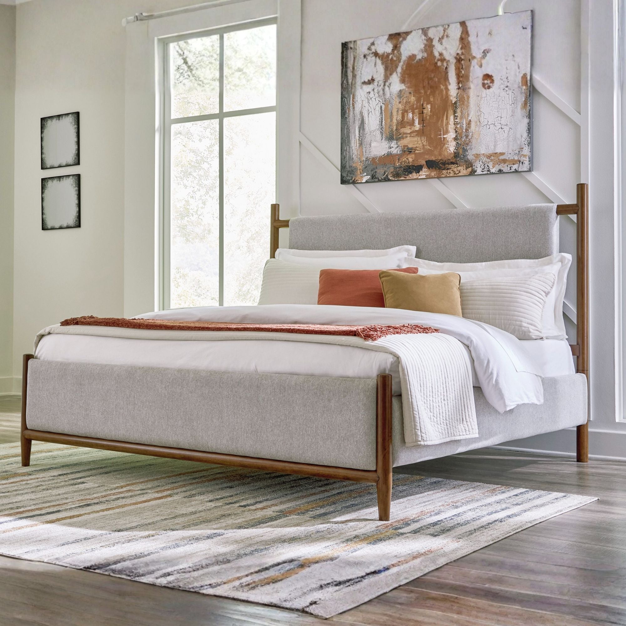 Signature Ashley Lyncott upholstered panel bed with padded headboard and dark wood finish, shown in a modern bedroom setting.