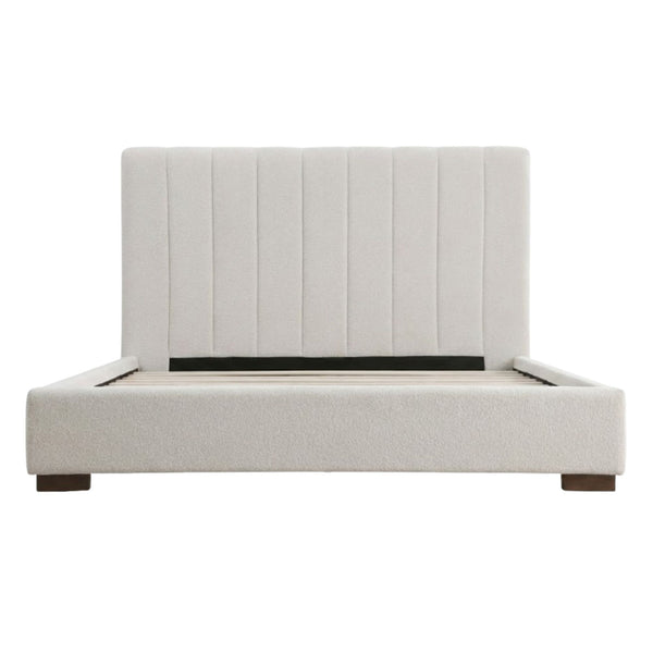 Channel-tufted beige platform bed by Brassex with a sleek, modern design and upholstered headboard, shown in a cozy bedroom setting.