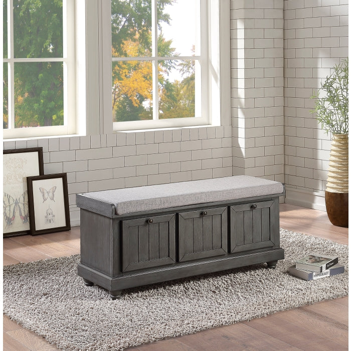 Grey Woodwell Lift-Top Storage Ottoman Bench by MAZ, showing a cushioned top and wooden base with storage space inside.