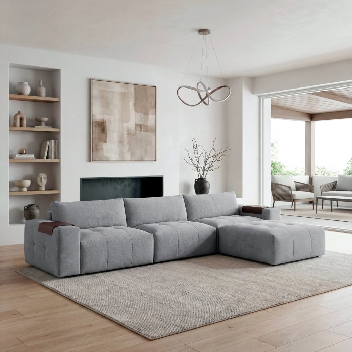 Grey Tidal 4-piece MAZ sectional sofa with ottoman, showing side view of modular design and plush cushions.