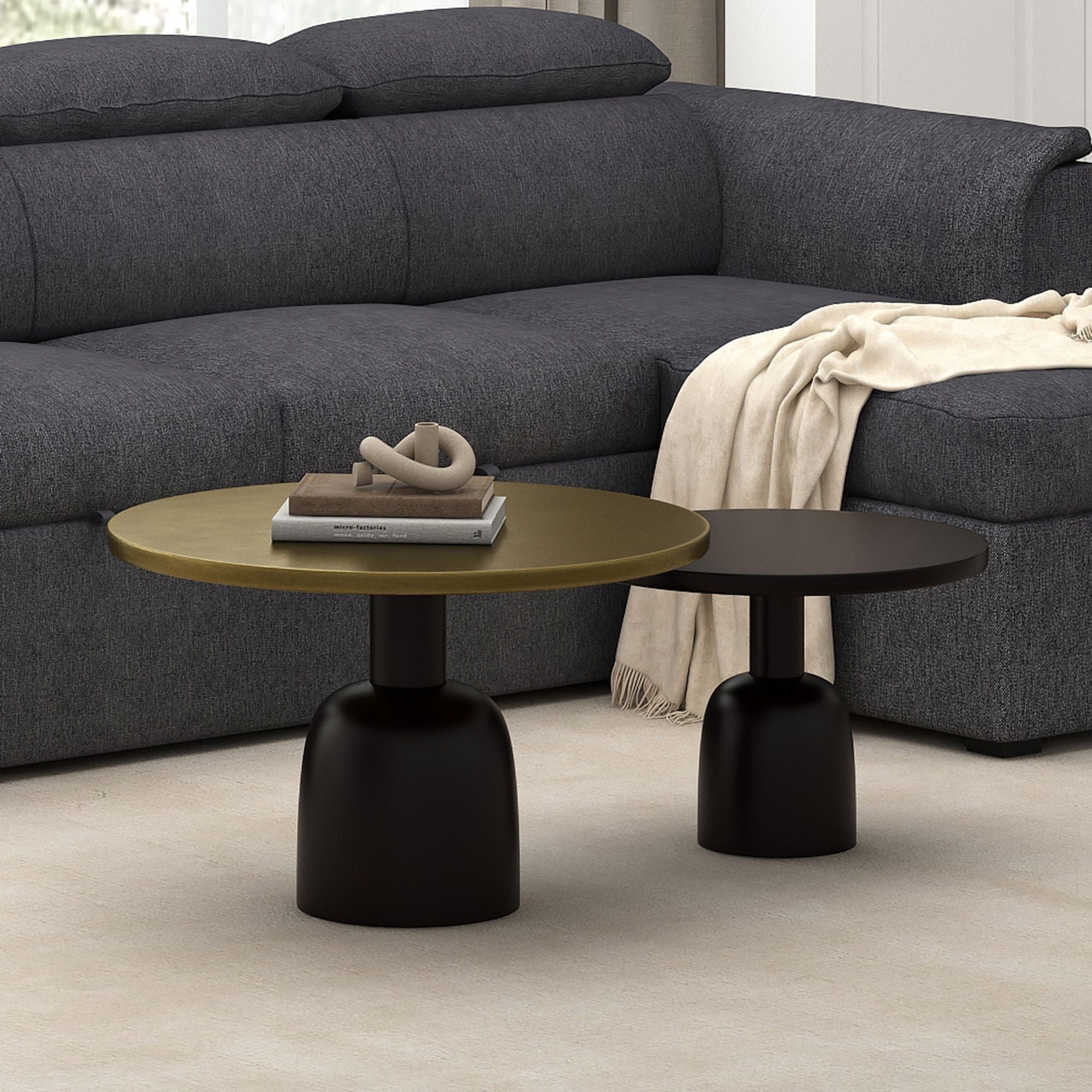 Two round coffee tables from World Wide's Adira set in antique gold and black finish, showing their elegant design and metal legs.