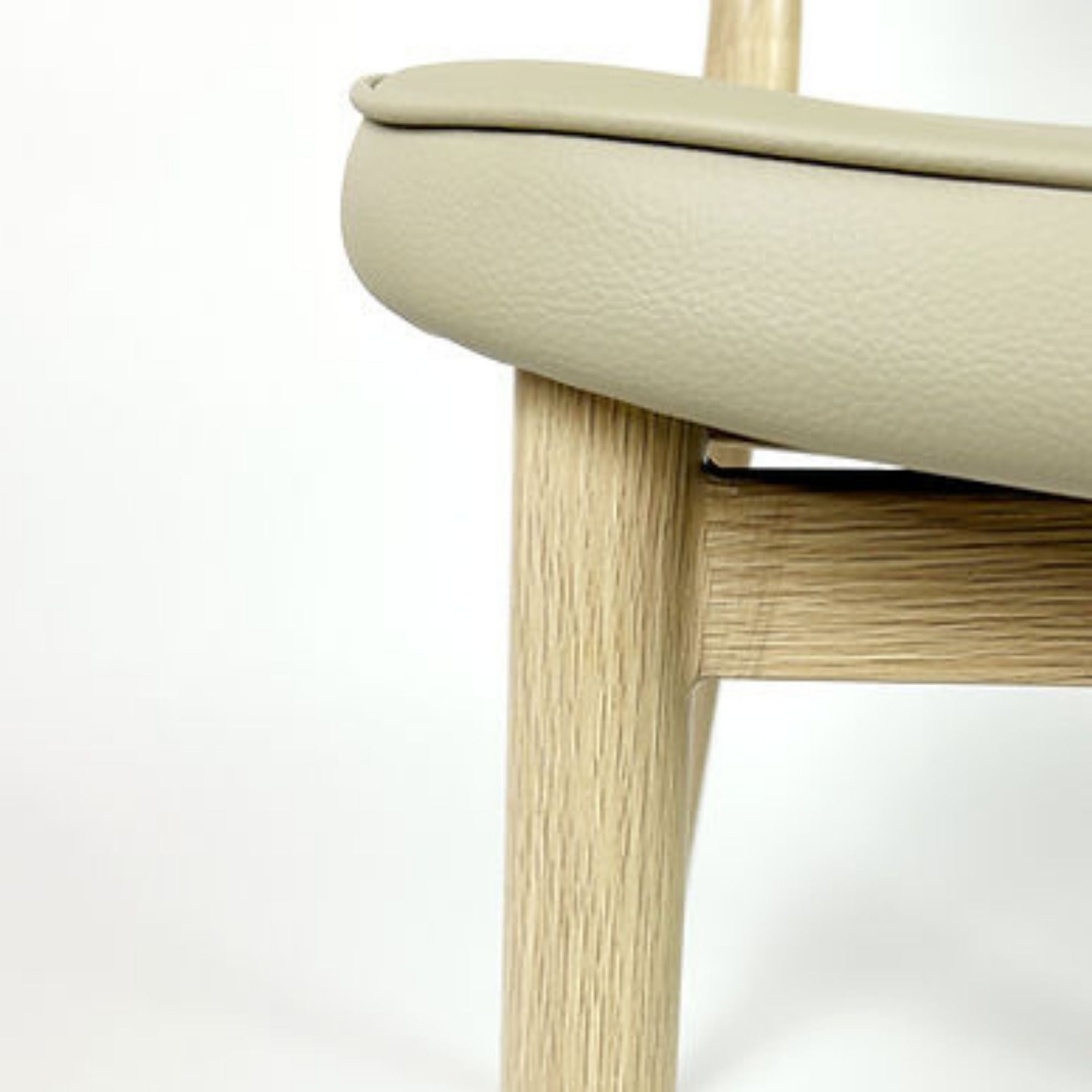 Beige Anton dining chair by Elite Living featuring a modern design with a cushioned seat and wooden legs.