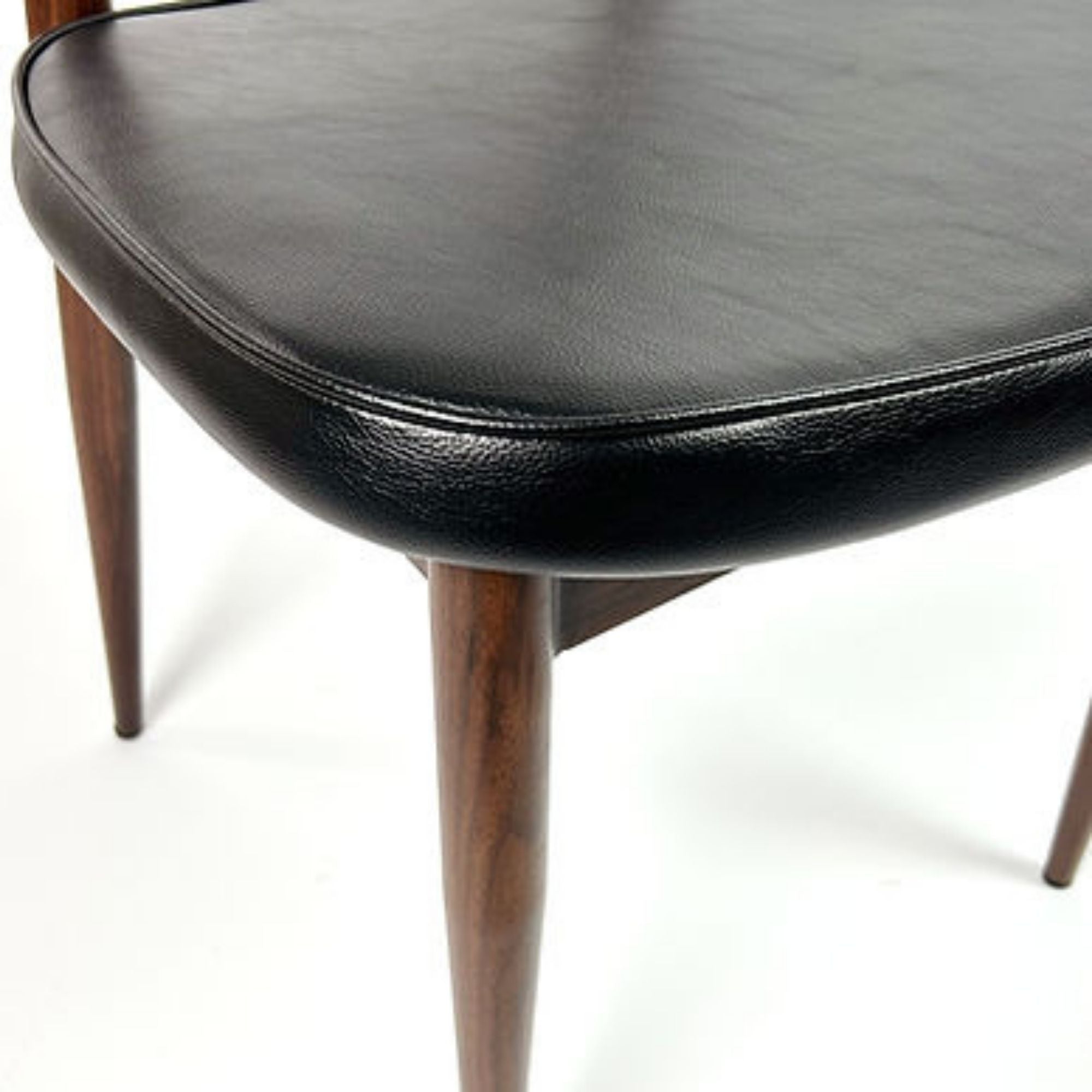 Elite Living Anton dining chair with black upholstered seat and sleek design, shown in a stylish dining room setting.