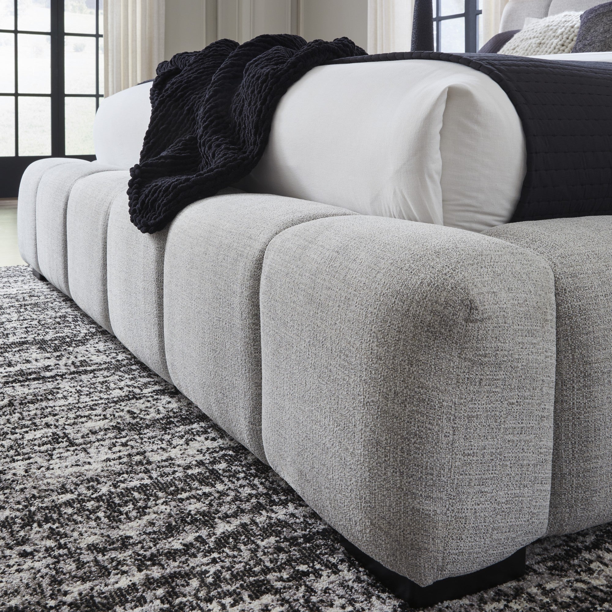 Light gray upholstered Ashley bed with padded headboard and sleek design, perfect for a modern bedroom setting.