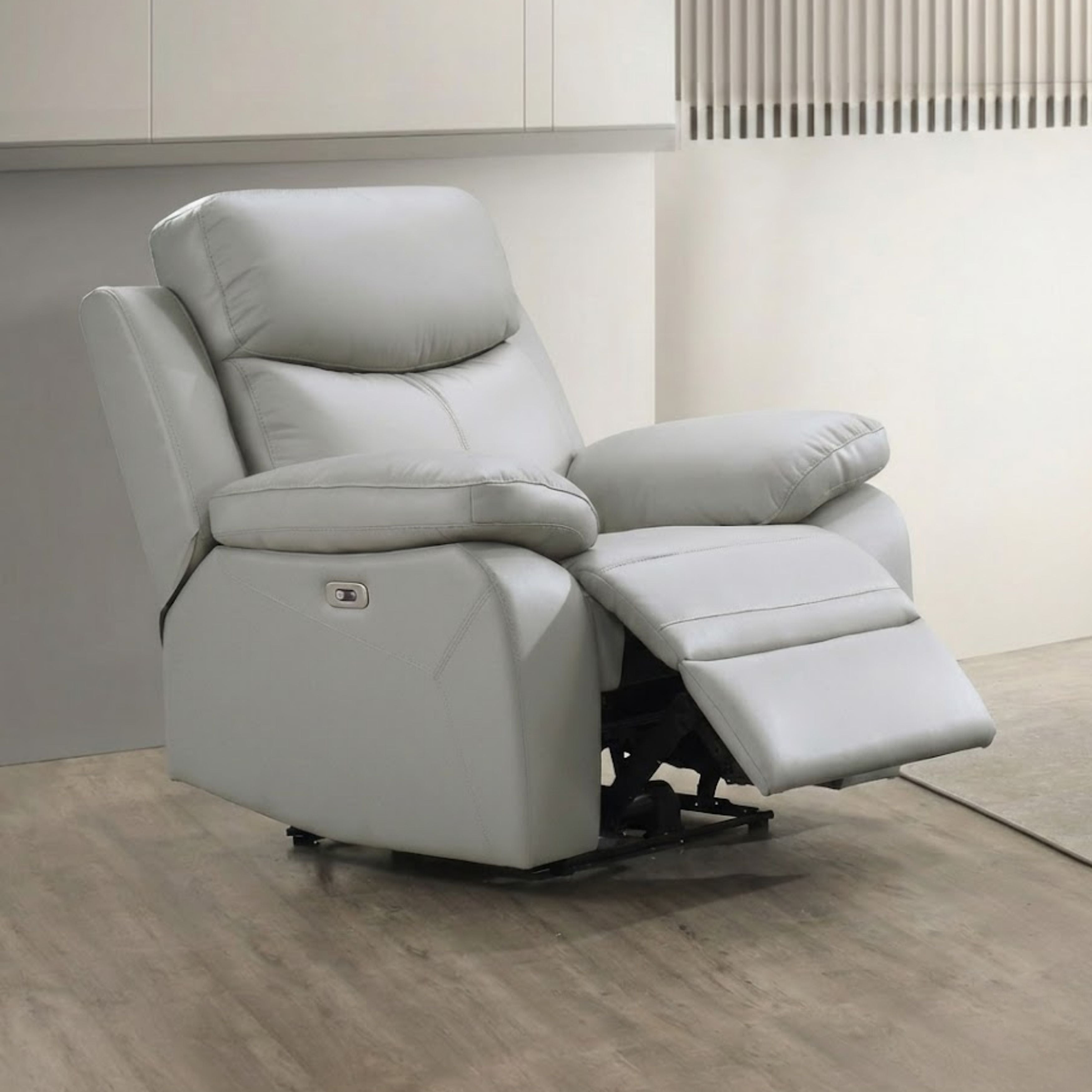 Light grey Axton Luxe leather power recliner chair by IFF, featuring a plush, ergonomic design with padded armrests and a reclining mechanism.