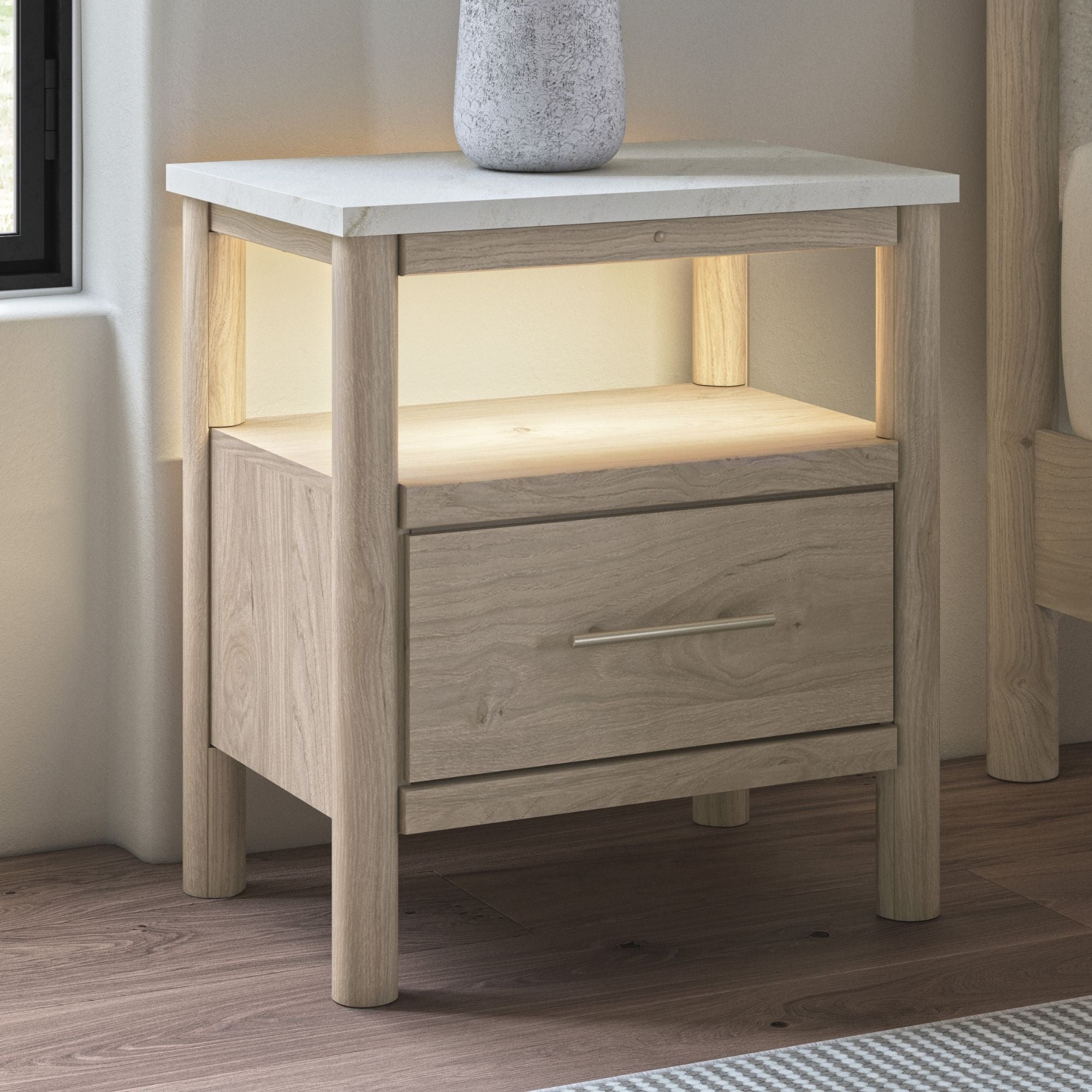 Natural wood Cadmori one drawer night stand by Signature Ashley with a sleek design and a single drawer, placed beside a bed in a bedroom.