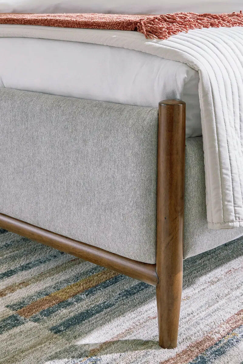 Close-up of the upholstered panel headboard from the Signature Design by Ashley Lyncott bedroom set in a cozy bedroom setting.