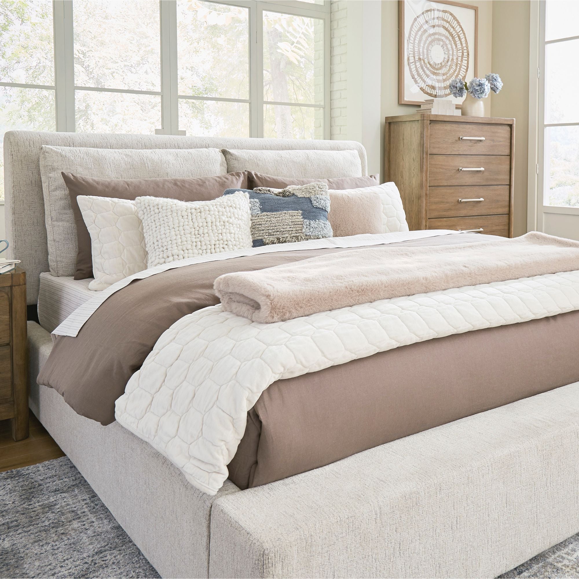 Signature Ashley Cabalynn upholstered bed with tufted headboard and neutral fabric, shown in a modern bedroom setting.