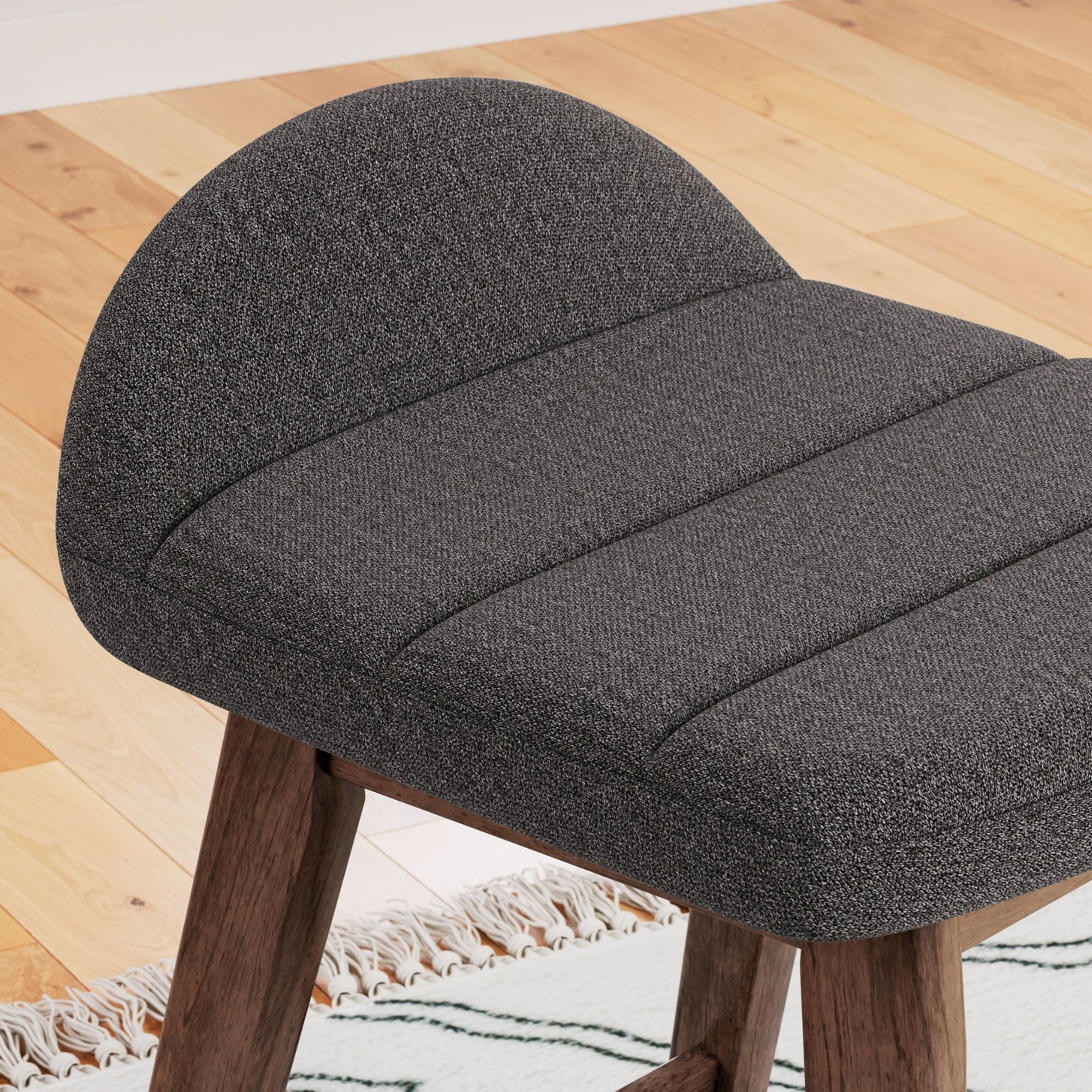 Set of two Signature Ashley Lyncott upholstered barstools in charcoal with padded seats and wooden legs.