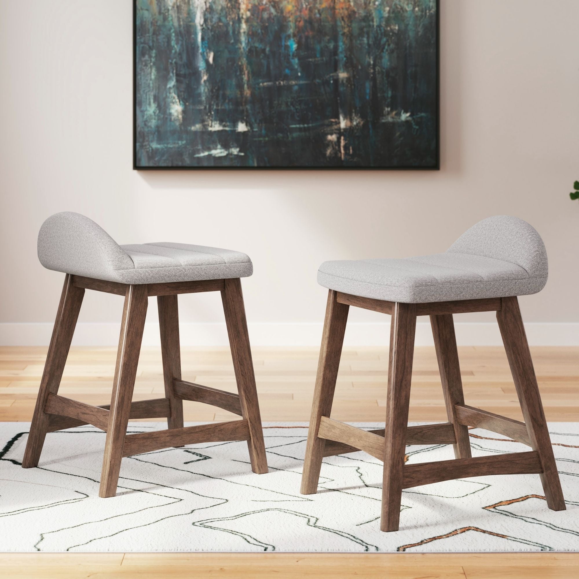 Set of two light grey upholstered Ashley Signature barstools with wooden legs and padded seats for modern home bar or kitchen counter.