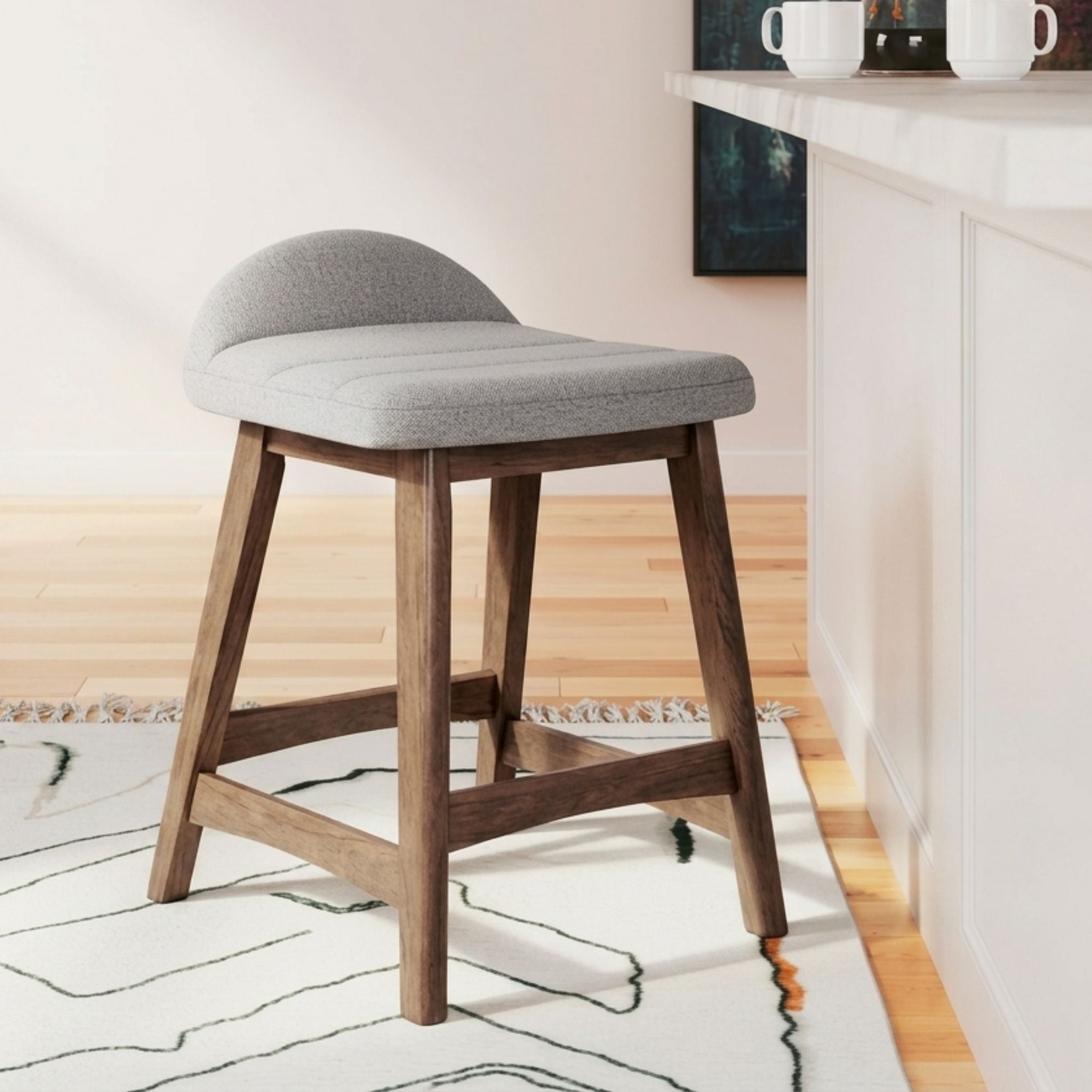 Set of two light grey upholstered Ashley Signature bar stools with wooden legs and cushioned seats.