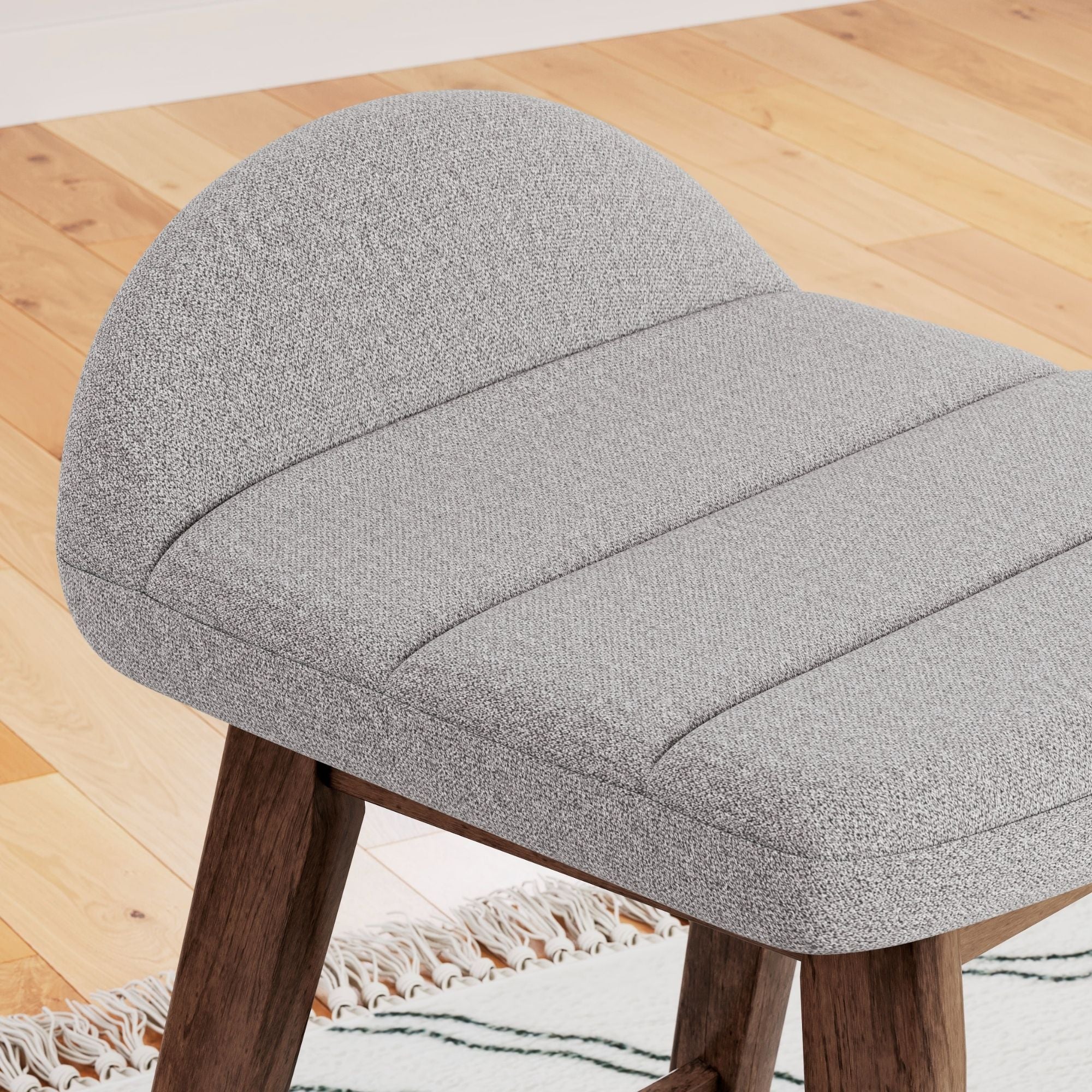 Set of two Signature Ashley Lyncott upholstered barstools in light grey with cushioned seats and sleek wooden legs.