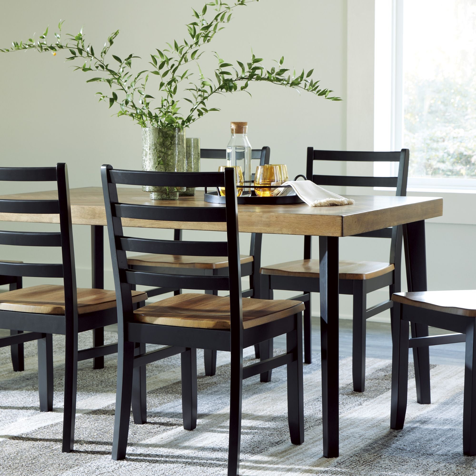 View of the Ashley Blondon 7-piece rectangular dining room set with brown and black finish, including table and six matching chairs.