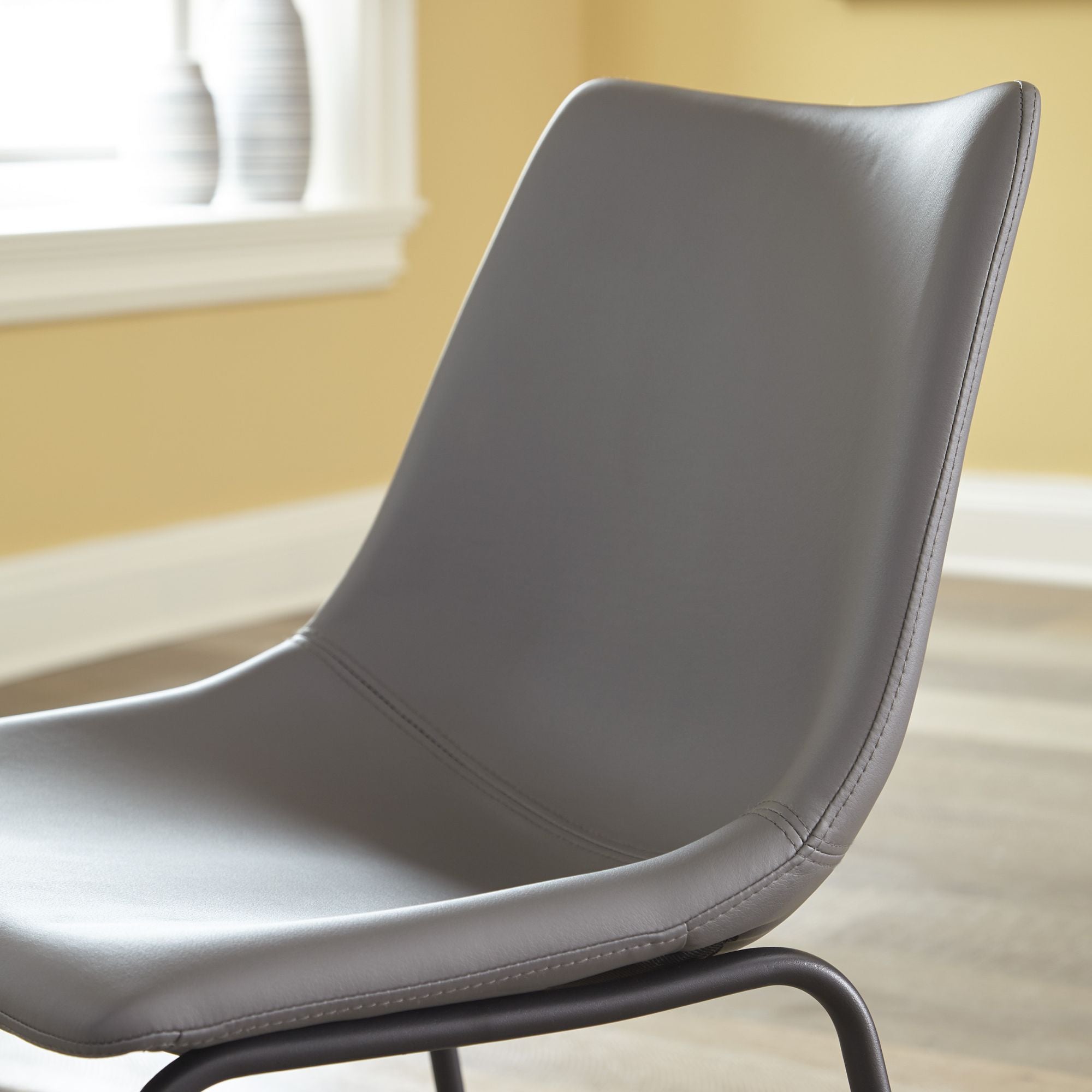Pair of grey Centiar UPH dining chairs by Signature Ashley, showcasing modern upholstered dining room seating with sleek design.