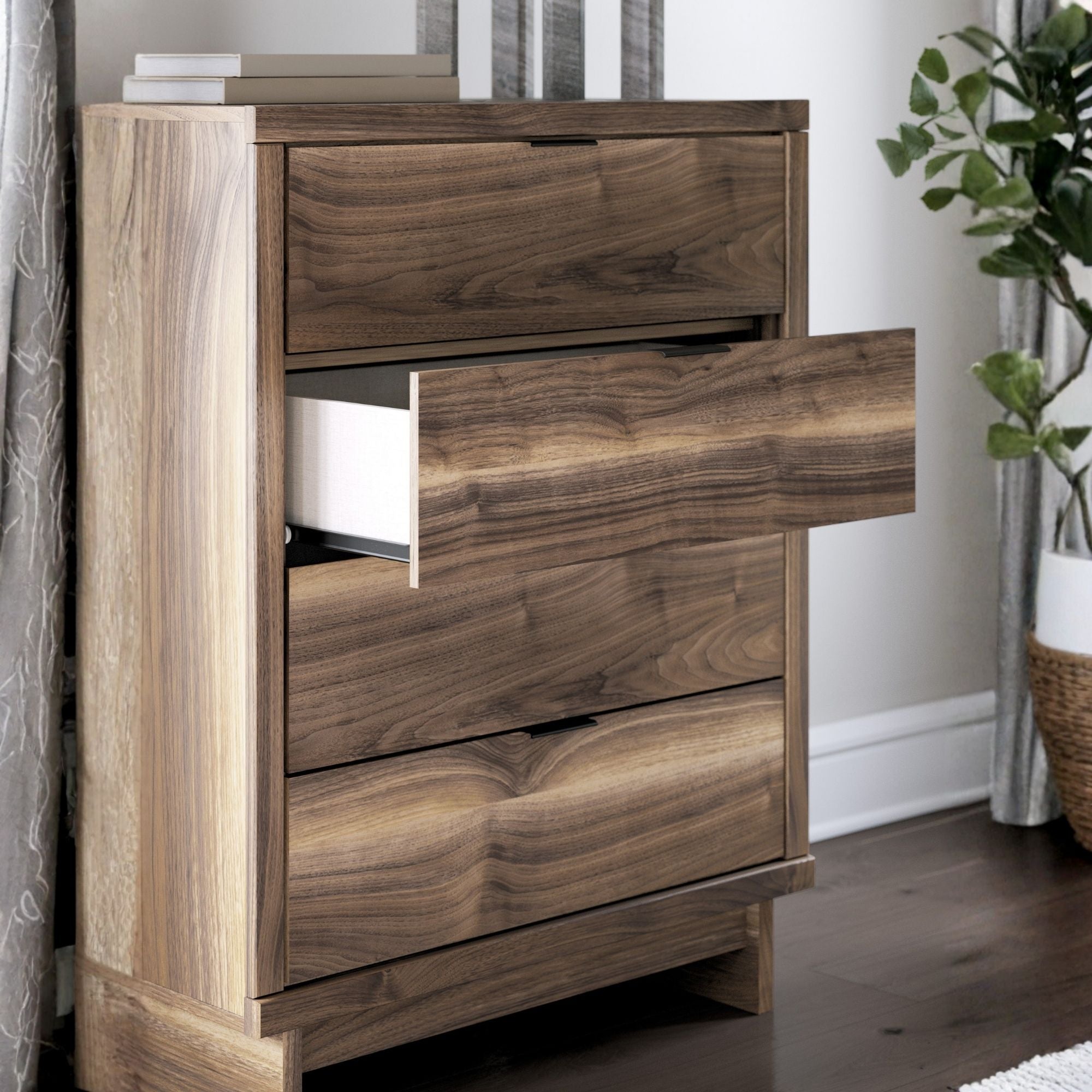Signature Ashley Chirason four-drawer chest showing wooden finish and sleek drawer handles in a bedroom setting.