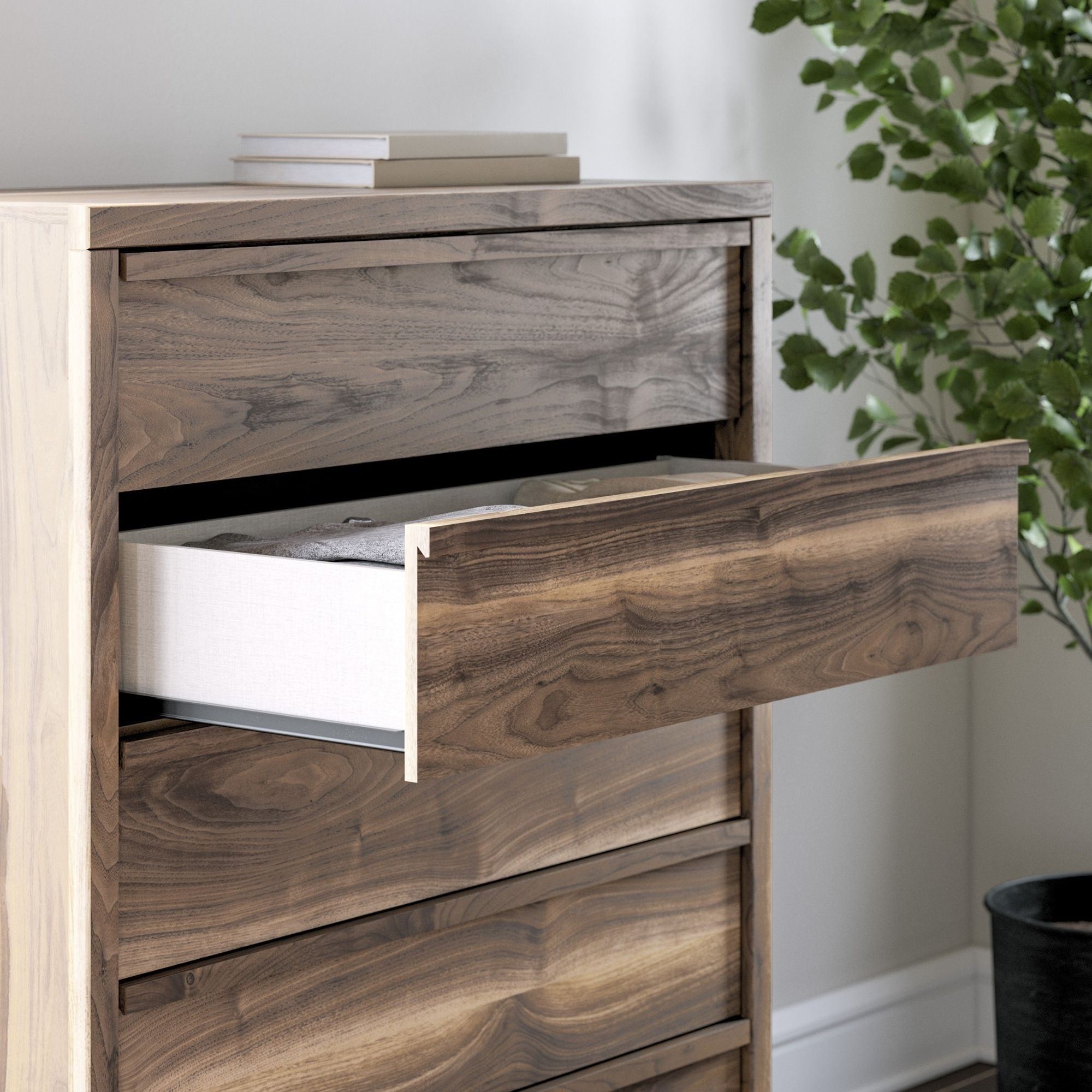 Signature Ashley Chirason four-drawer chest showing a wooden bedroom dresser with sleek drawer handles and a polished finish.