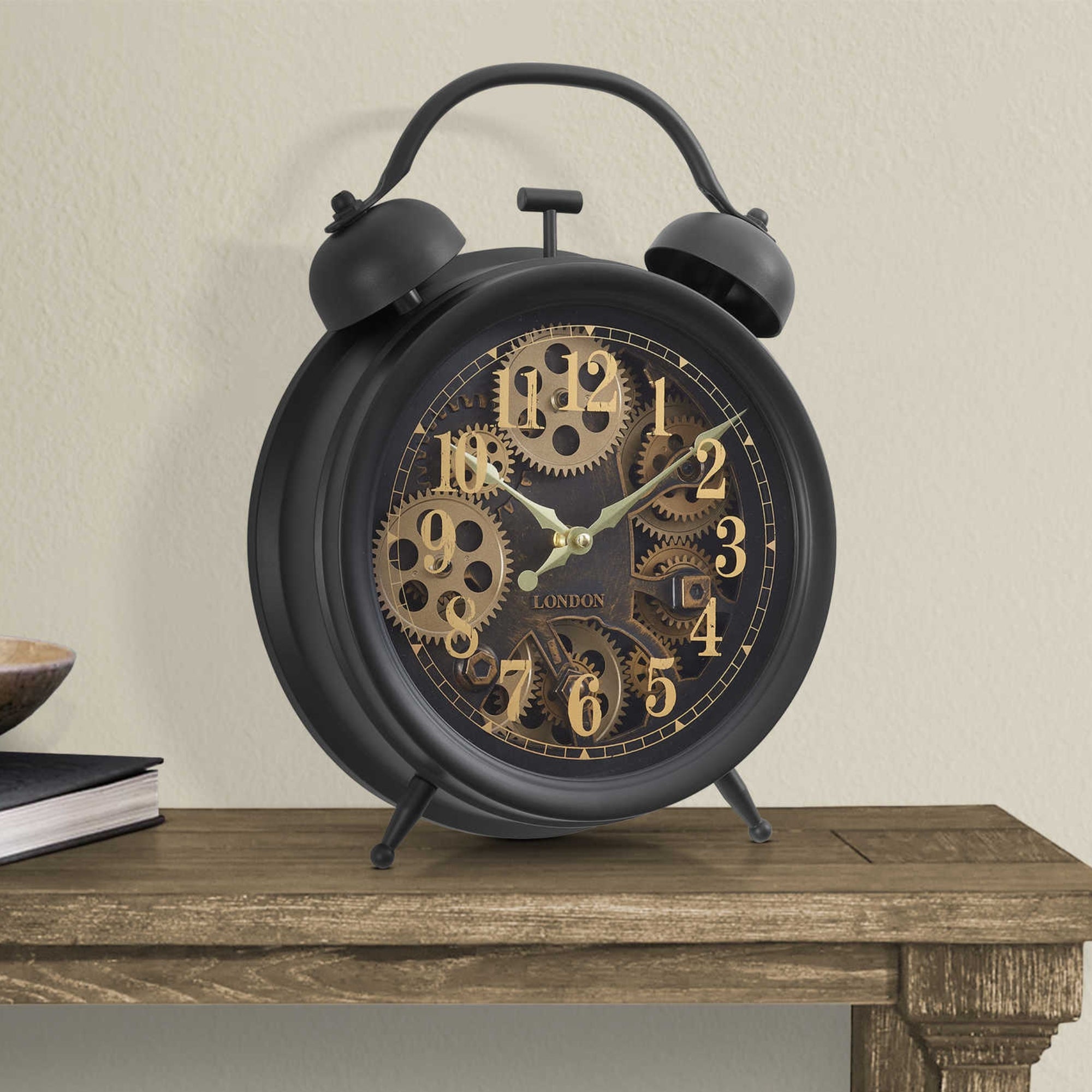 Dark brown tabletop clock with visible gear mechanism, designed by Monarch Specialties, showcasing a vintage-inspired clock face and gears.