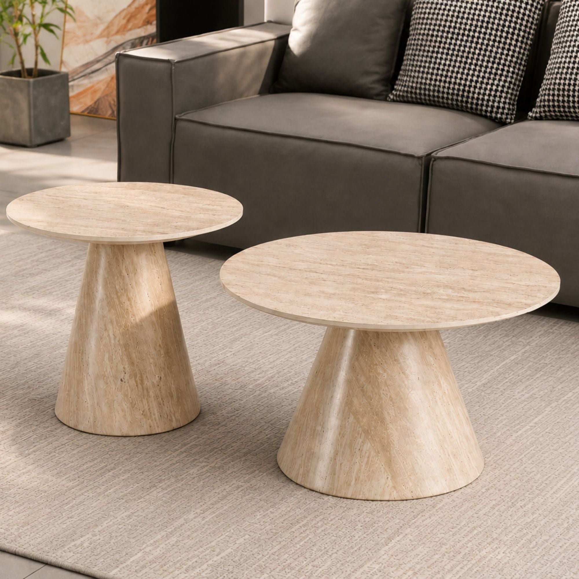 Set of two round coffee tables with Sorrento travertine tops and sleek metal legs by IFF, arranged together in a modern living room.