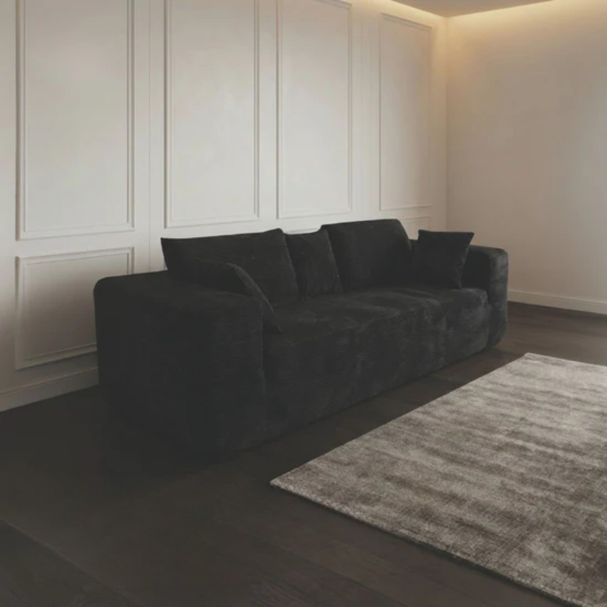 Black compression low-profile sofa by Taste Living, showcasing sleek design and plush cushions in a modern living space.