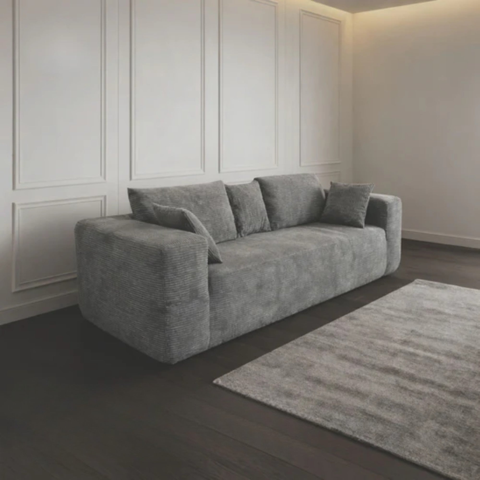 Grey compression low-profile sofa by Taste Living, showcasing its sleek design and comfortable cushions in a modern living space.