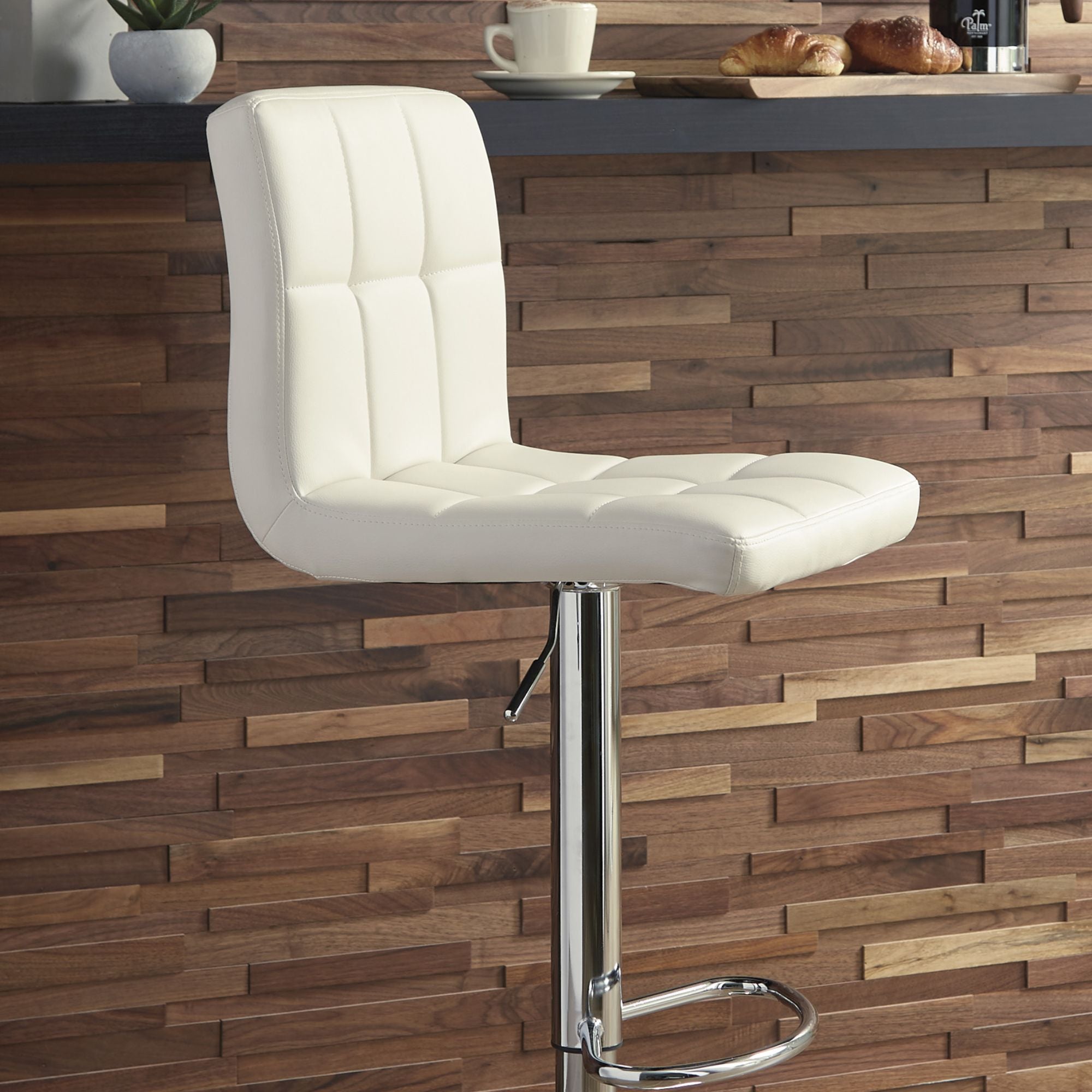 Cream Bellatier Tall UPH Swivel Bar Stool by Signature Ashley, featuring a cushioned seat and sleek wooden legs.