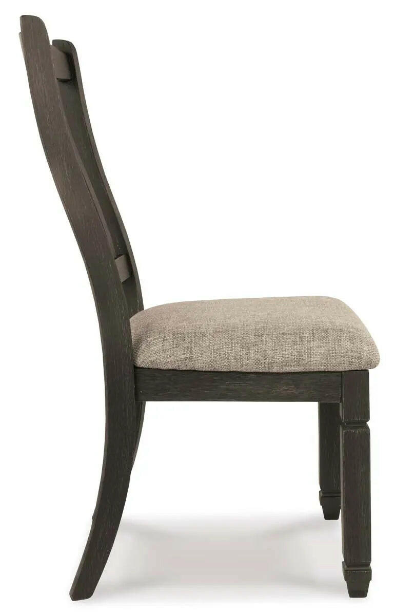 Side view of the Ashley Tyler Creek dining room set with two-tone finish, featuring arm chairs and a spacious table.