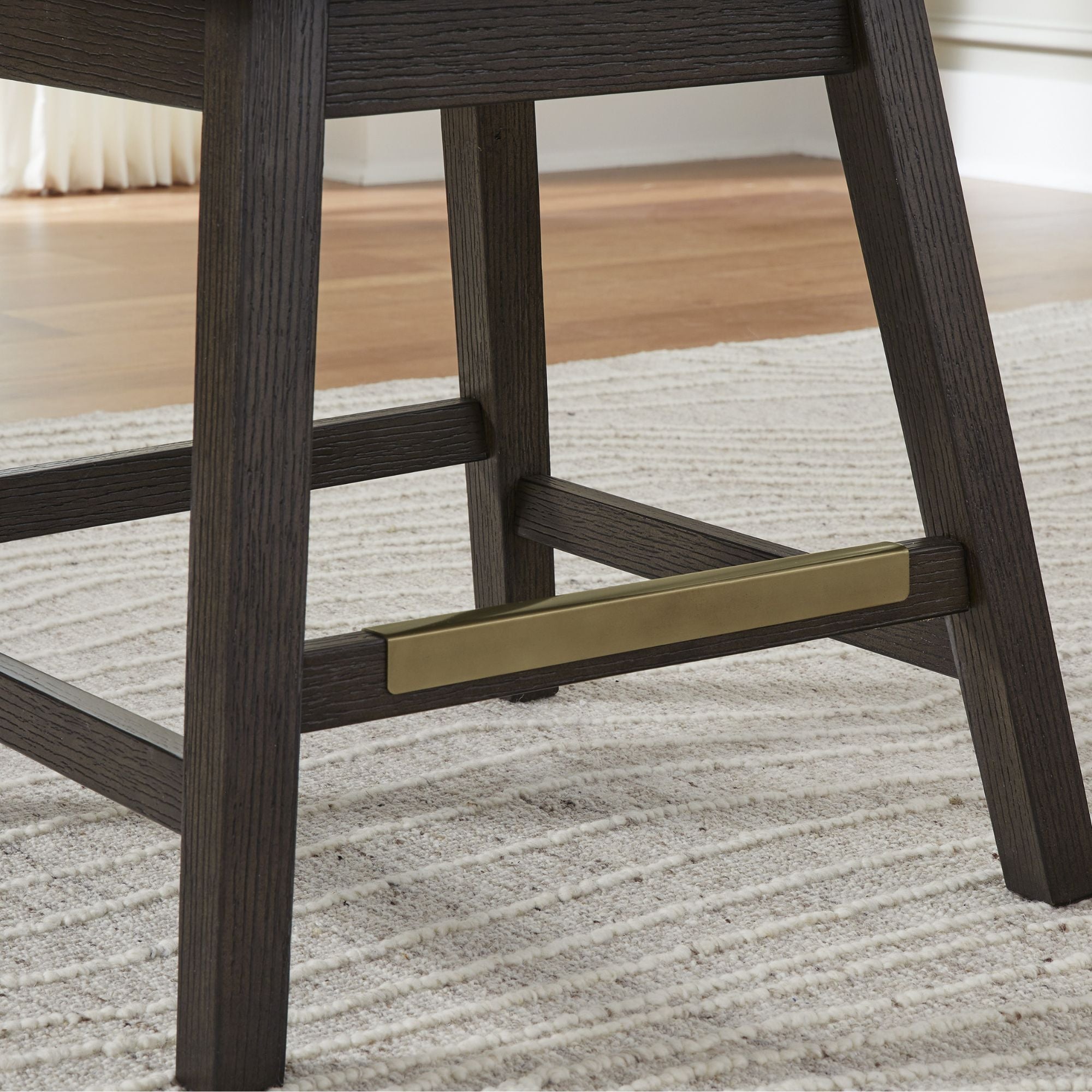Two Signature Ashley Burkhaus UPH swivel bar stools with dark wooden legs and upholstered seats, set against a modern kitchen background.