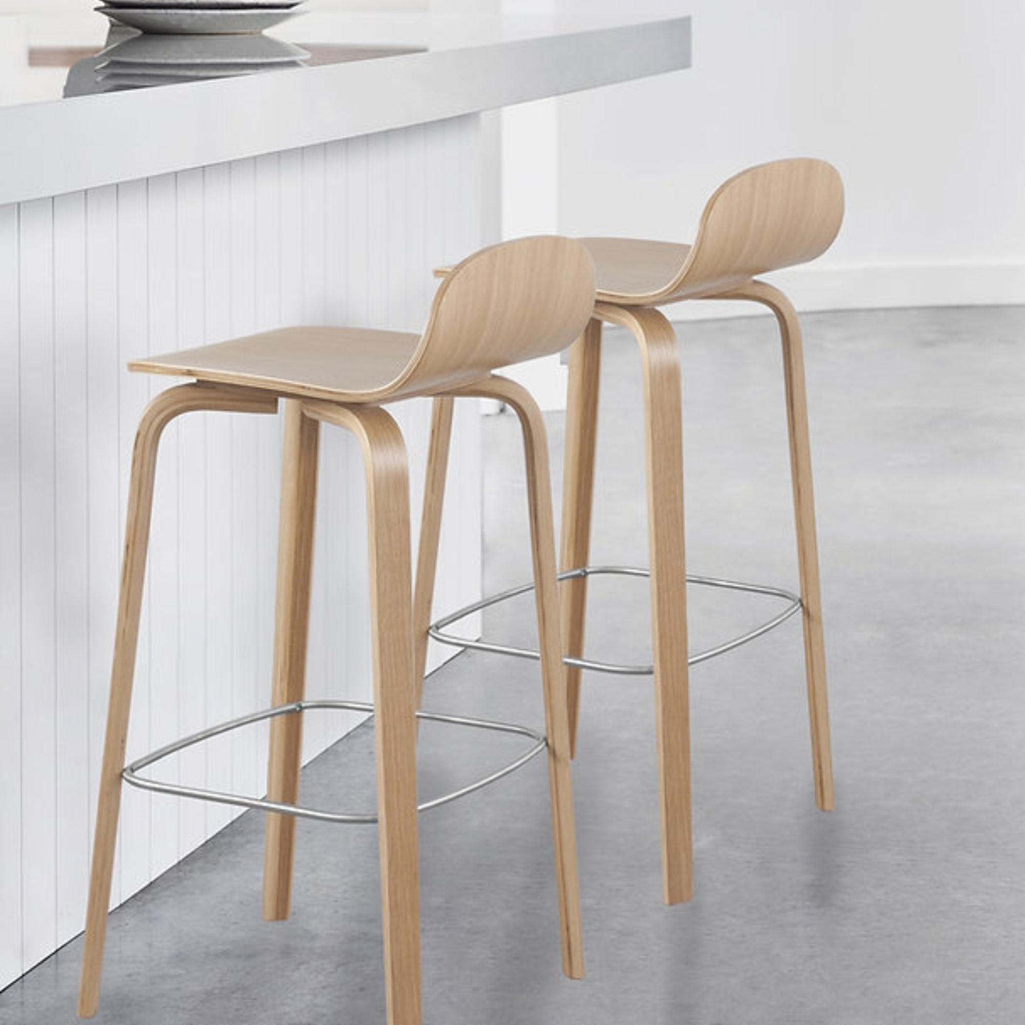 Natural wooden Glen Modern bar stool from Elite Living with a sleek design and light wood finish, suitable for counter seating.