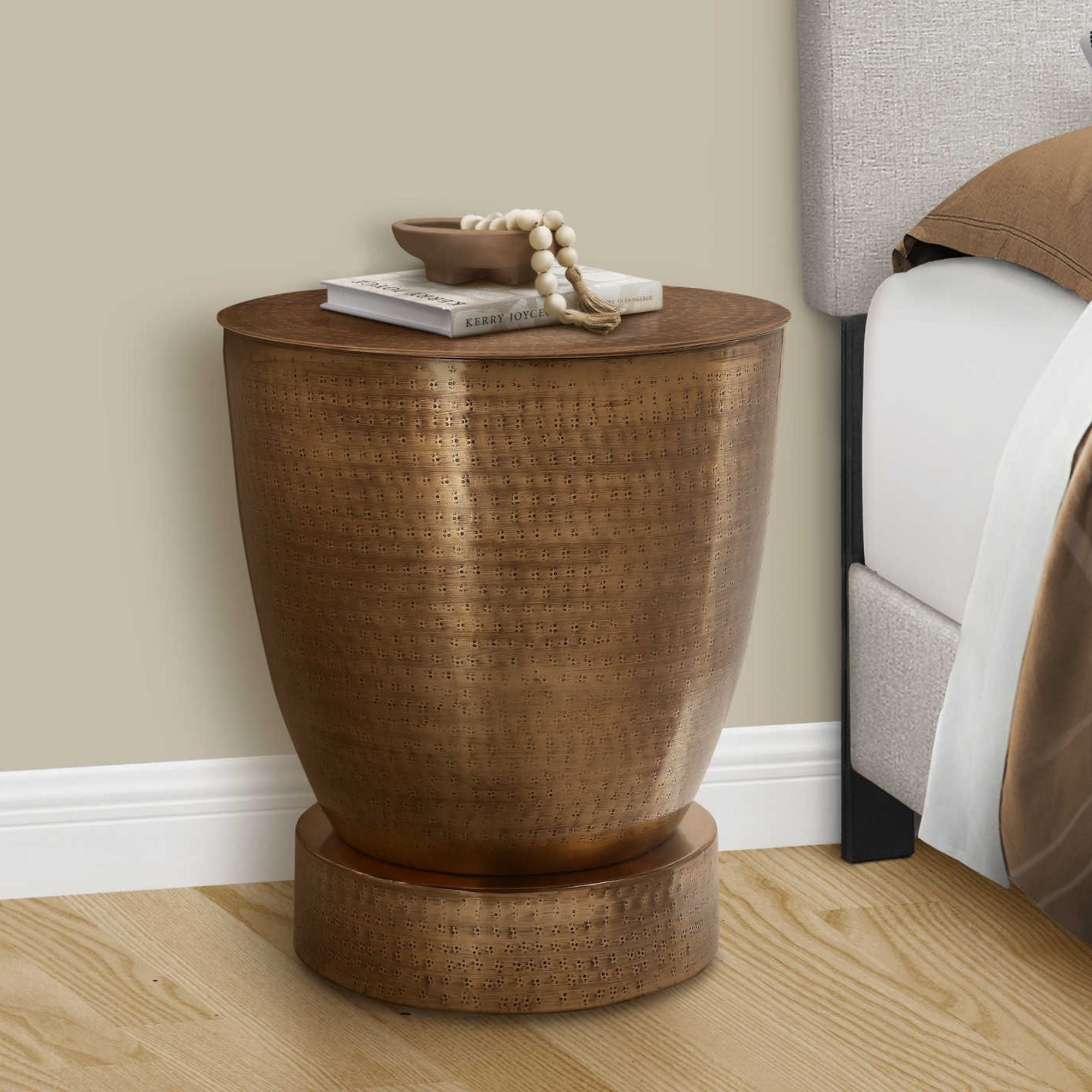 Amonarch Specialties Avelon copper accent table with a sleek, modern design and round top, placed in a contemporary living space.
