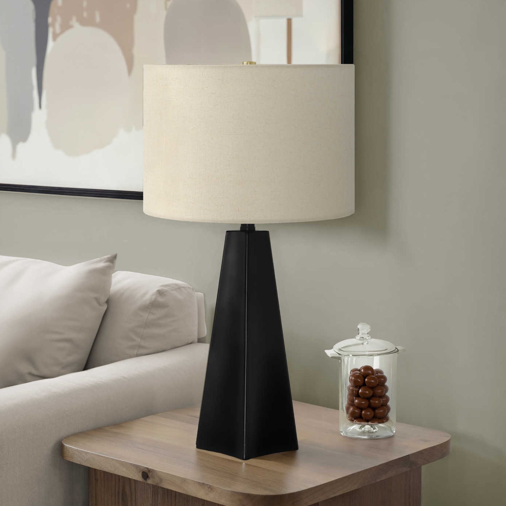 Modern black resin table lamp with beige fabric shade, 27-inch height, by Monarch Specialties.