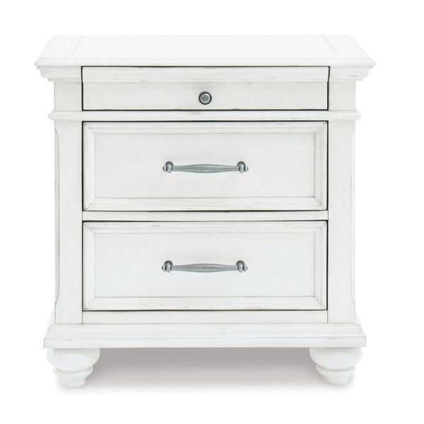 Signature Ashley Kanwyn three-drawer nightstand with wood finish, featuring sleek handles and a modern bedroom decor setting.