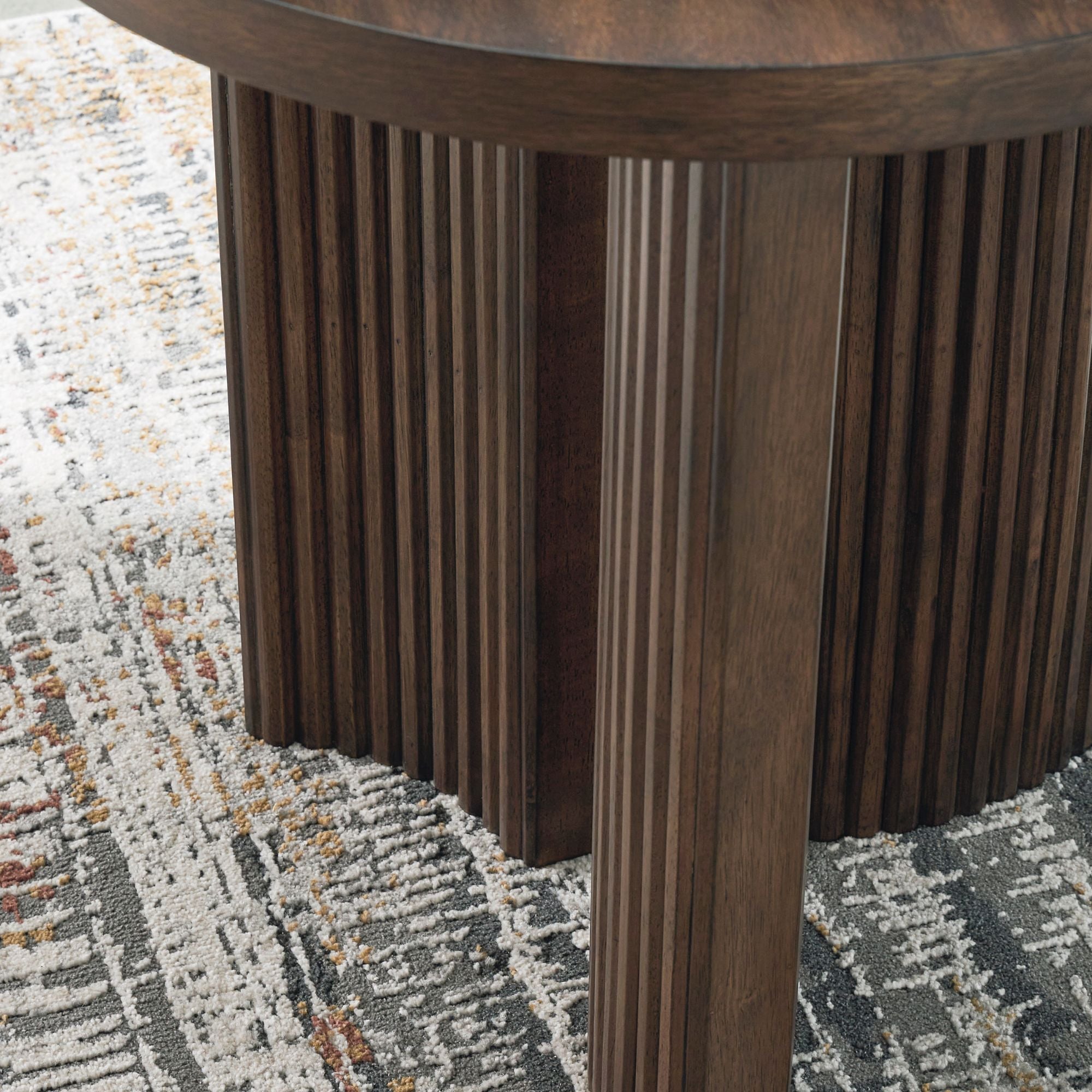 Round Korestone end table by Signature Design by Ashley with a sleek surface and sturdy wooden legs for modern living rooms.