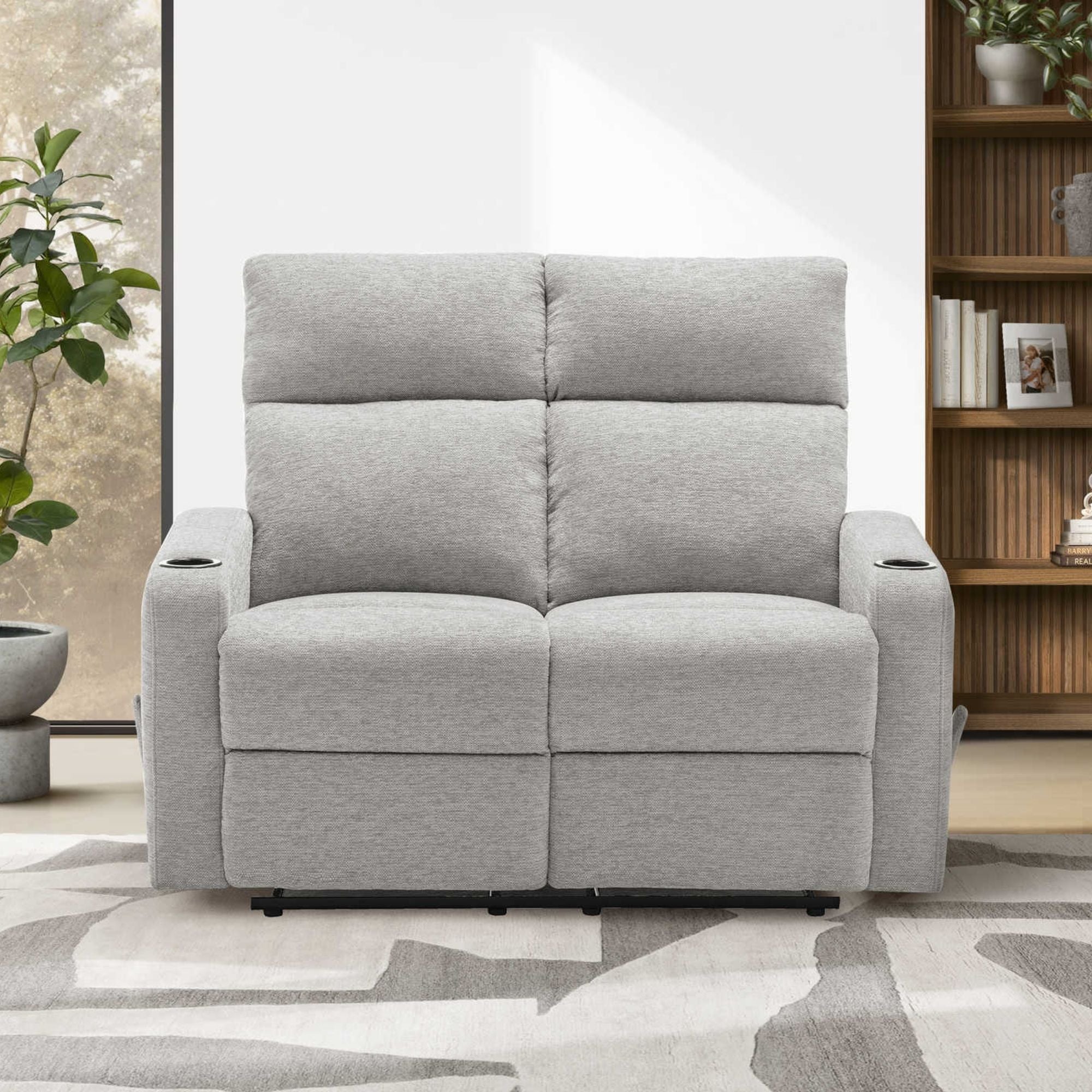Light grey Monarch Specialties Arden reclining loveseat with built-in cupholders, plush fabric, and padded armrests.