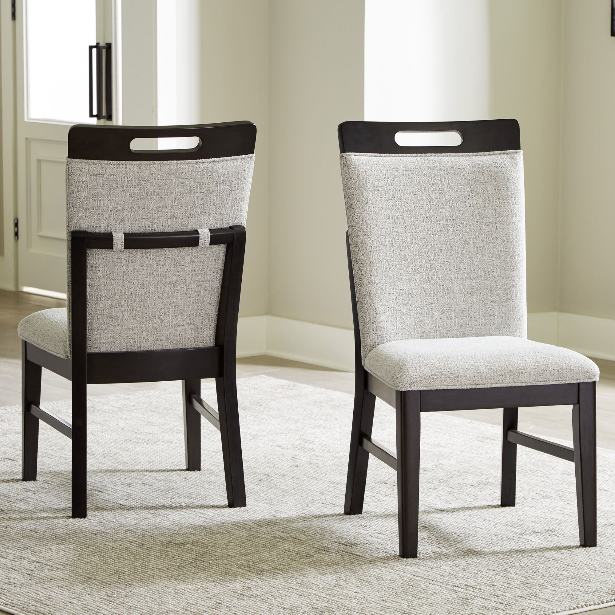 Set of two Neymorton Collection dining UPH side chairs by Signature Ashley, featuring upholstered seats and sleek wooden legs.