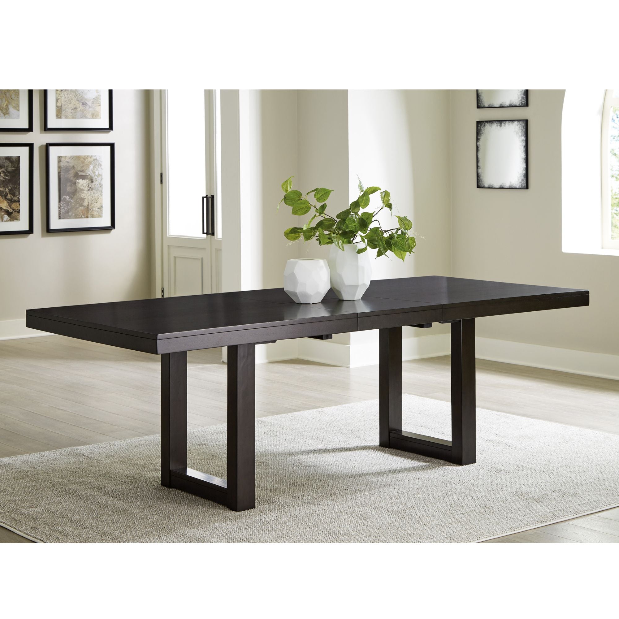 Neymorton dining extension table by Signature Ashley in a modern dining room setting, showing the wood finish and extended surface.