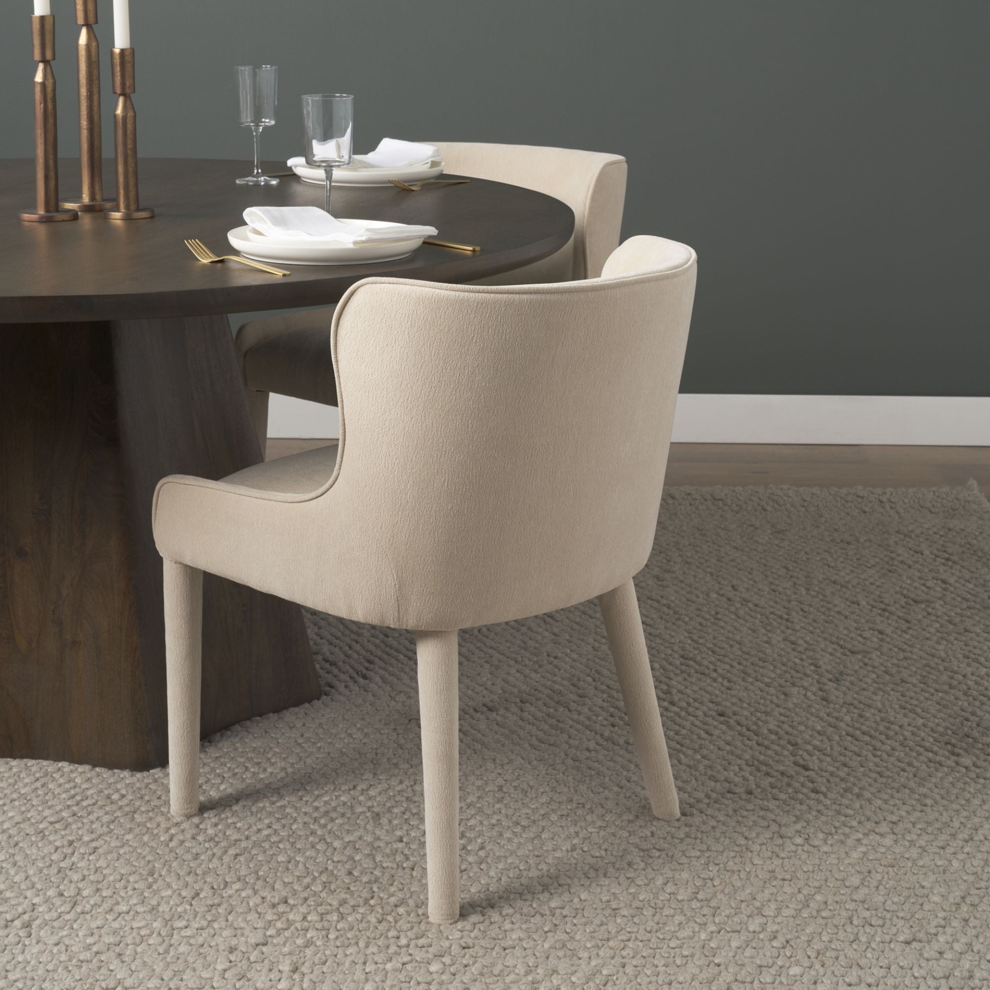 Cream chenille Nolan dining chair by Mercana Furniture with sleek wooden legs and modern design, shown from a side angle.