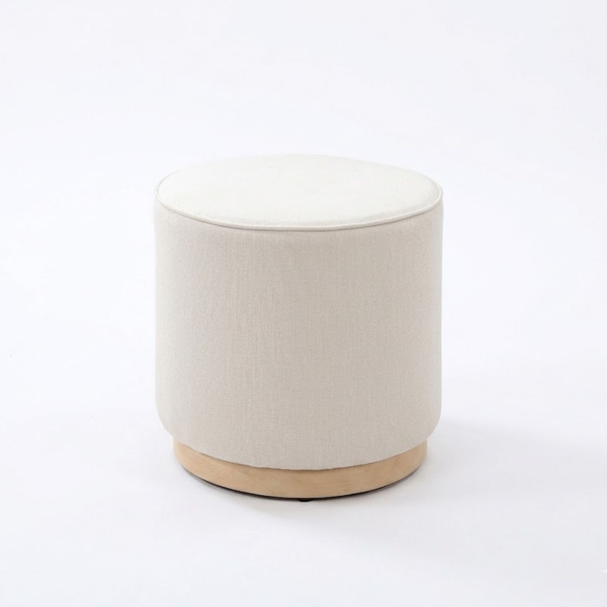 Modern round ottoman with cream fabric by IFF, featuring a sleek design and soft upholstery, perfect for living room decor