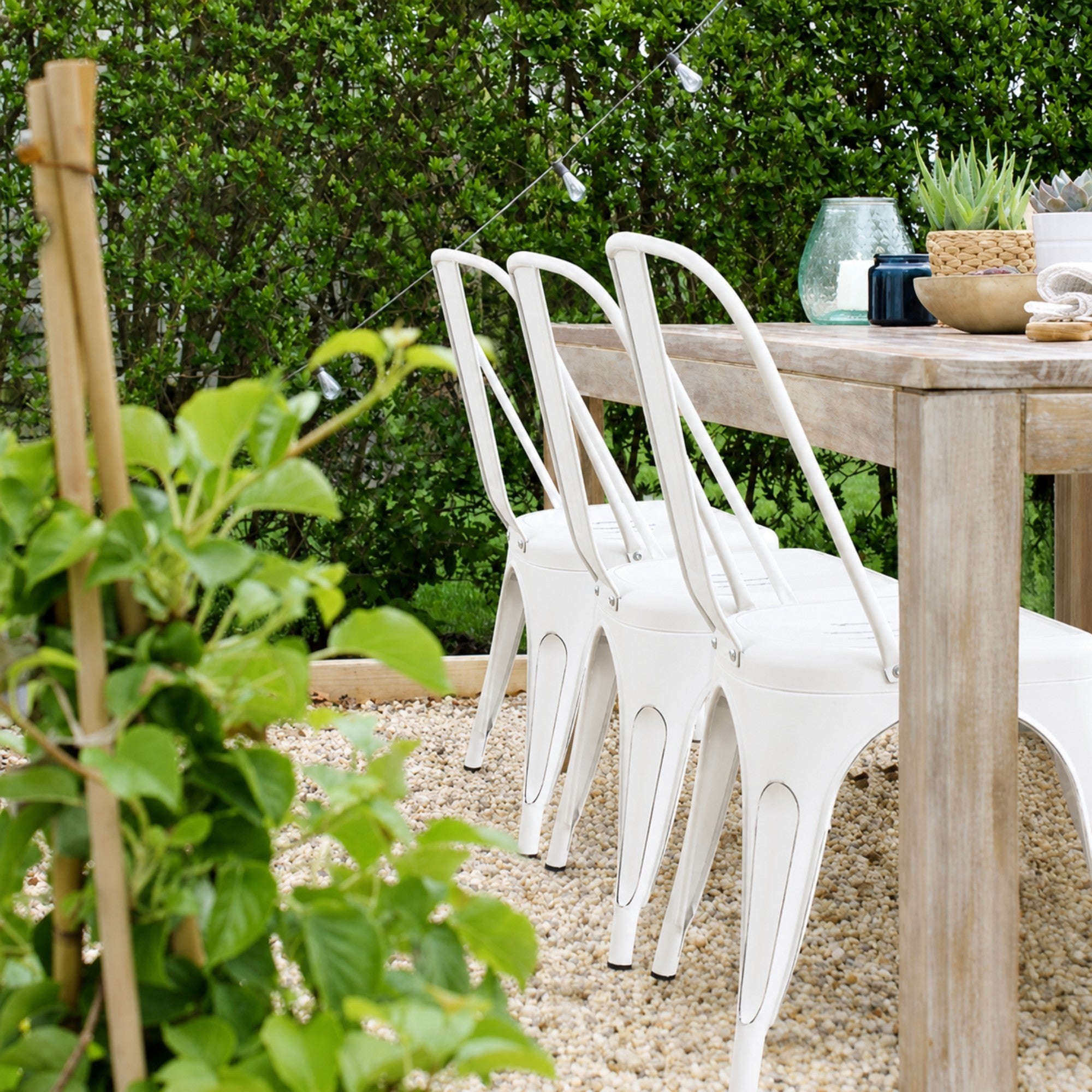 Pair of white Rochelle stackable dining chairs by Elite Living, outdoor-friendly chairs with sleek design and sturdy construction.