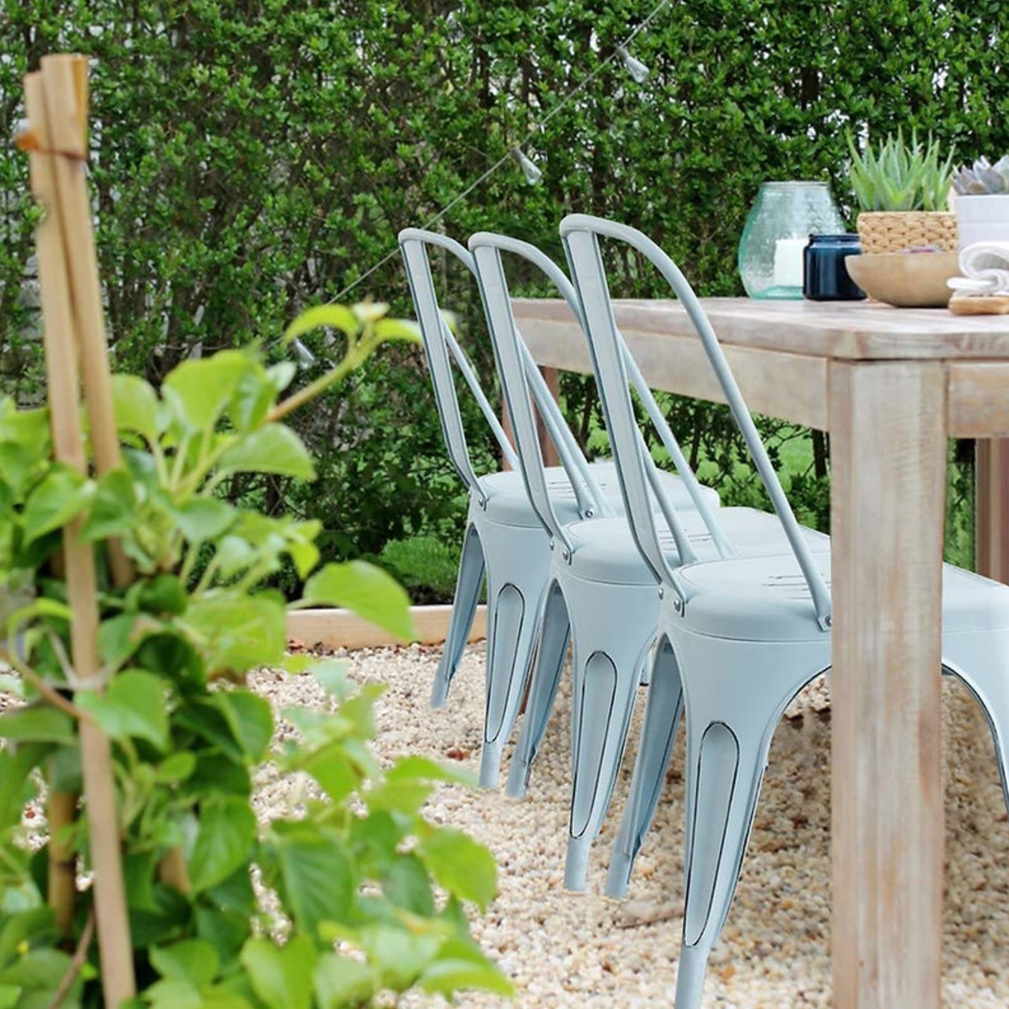 Set of two Elite Living Rochelle light blue stackable outdoor dining chairs with metal frames and cushioned seats.