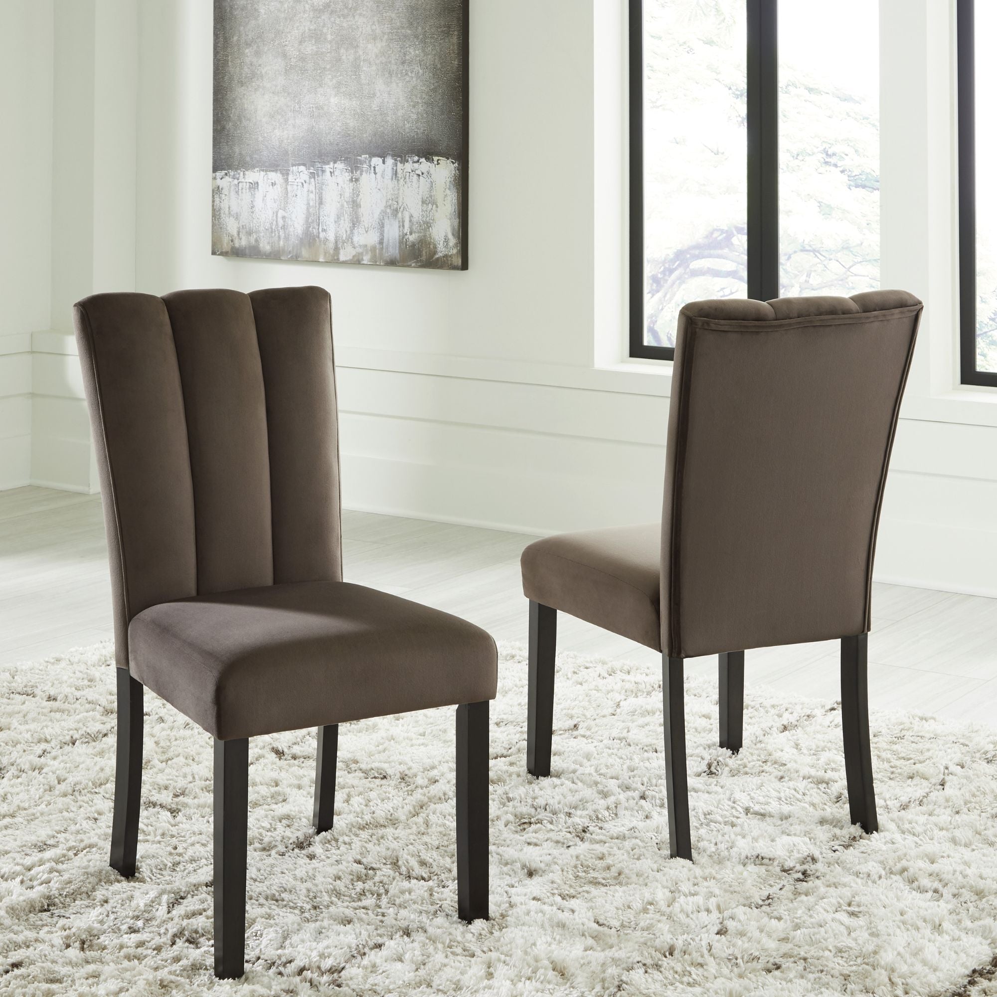 Two Jeshina Dining UPH Side Chairs by Signature Ashley with dark wooden legs and upholstered seats, set against a neutral background.