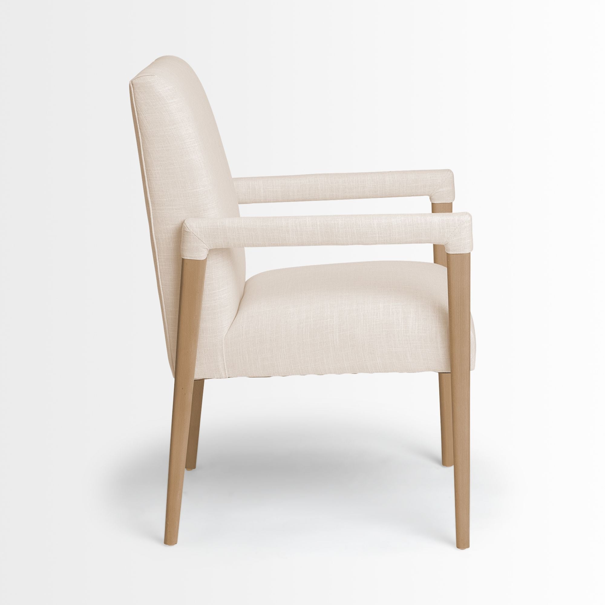 Cream Mercana Palisades Dining Armchair with plush upholstery and wooden legs, perfect for modern dining room decor.