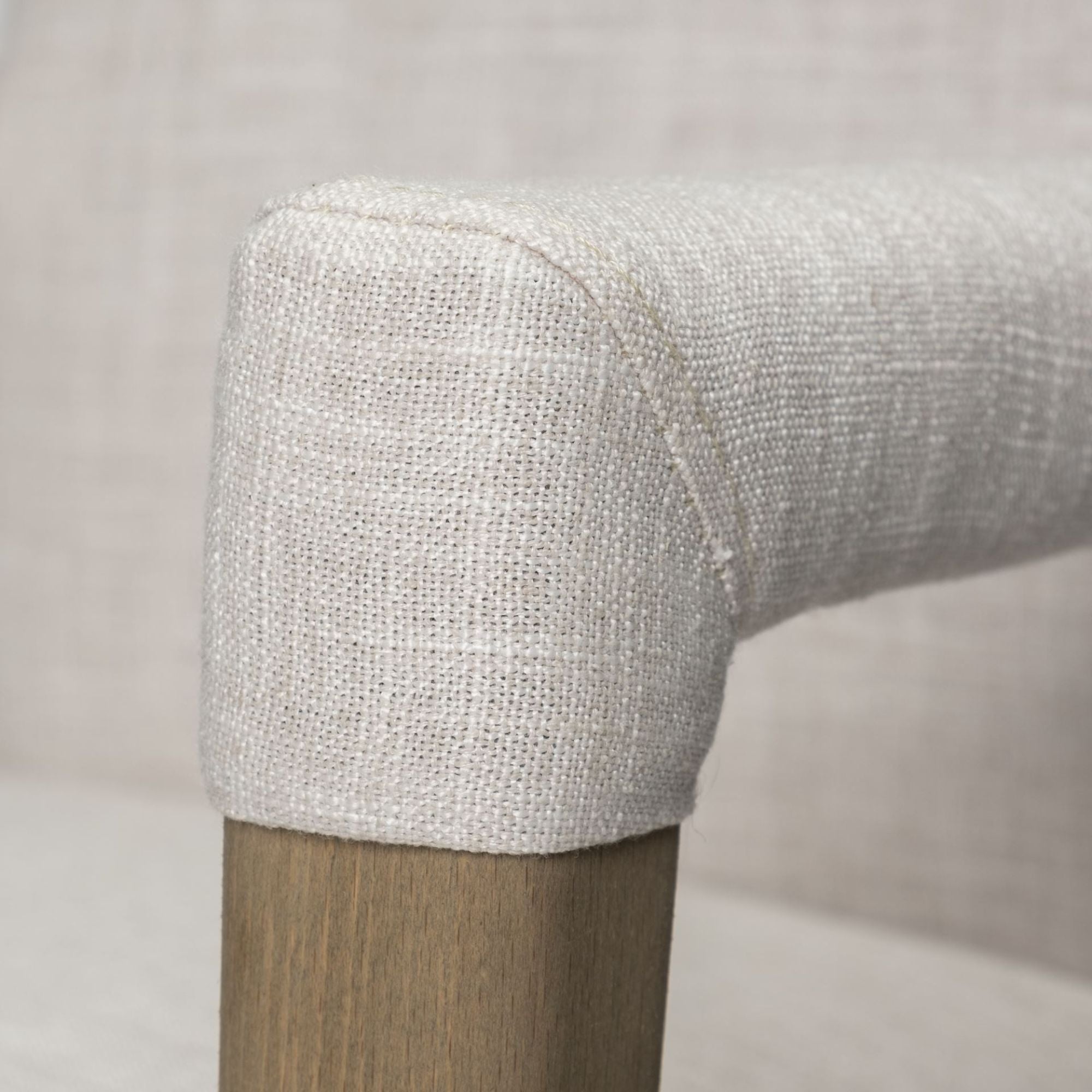 Cream Palisades Dining Armchair by Mercana Furniture with cushioned seat and stylish wooden armrests, ideal for modern dining rooms.