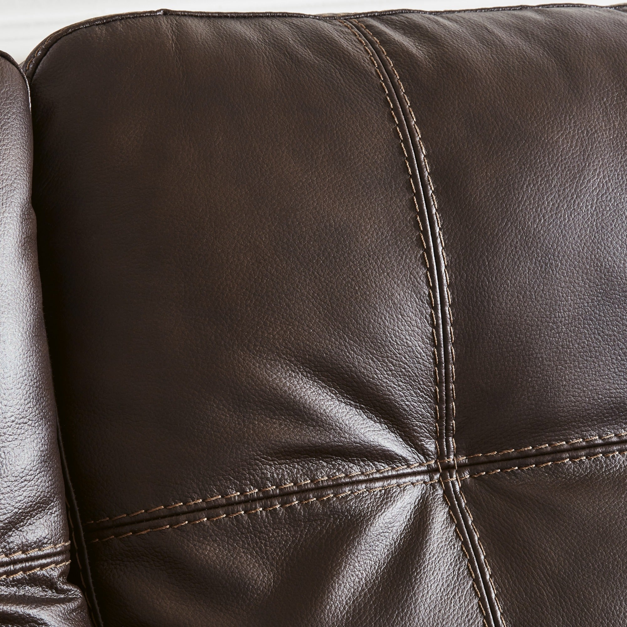 Dark brown Santorine leather sofa by Signature Design Ashley, showing plush cushions and modern armrests in a living room setting.