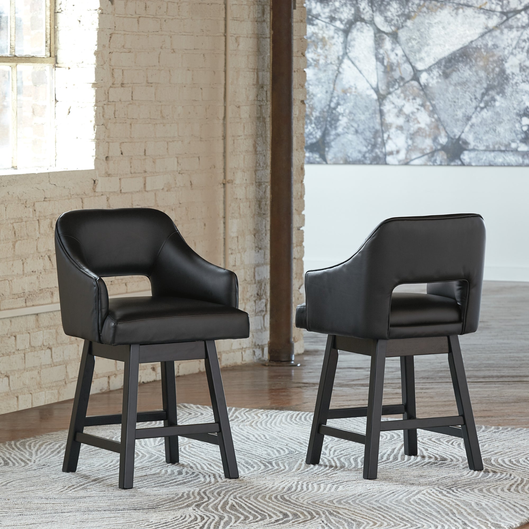 Set of two Ashley Tallenger UPH swivel barstools with black and dark brown upholstery, featuring modern design and sturdy metal bases.