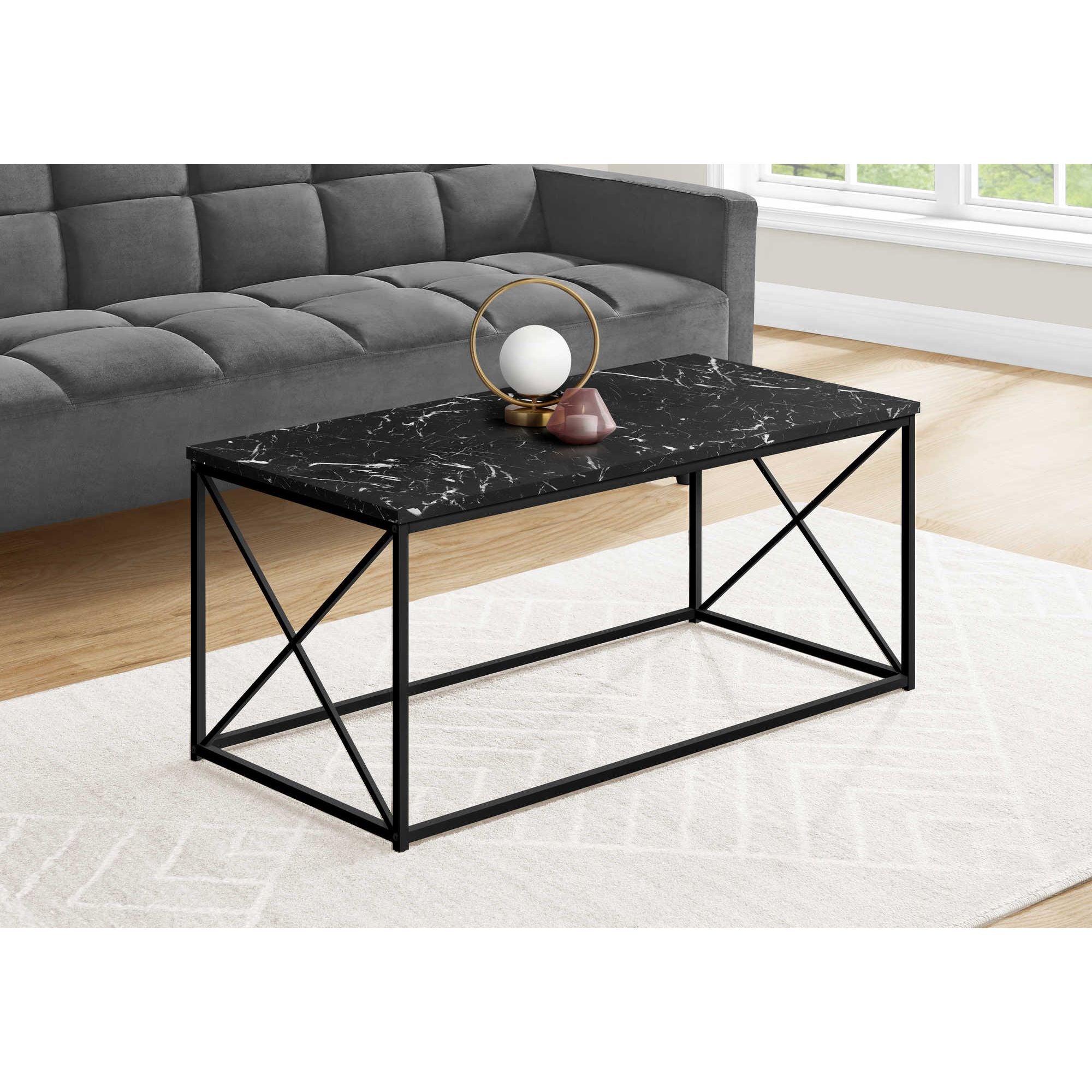 Vetra coffee table with black marble top and sleek black metal legs, modern design in a living room setting.