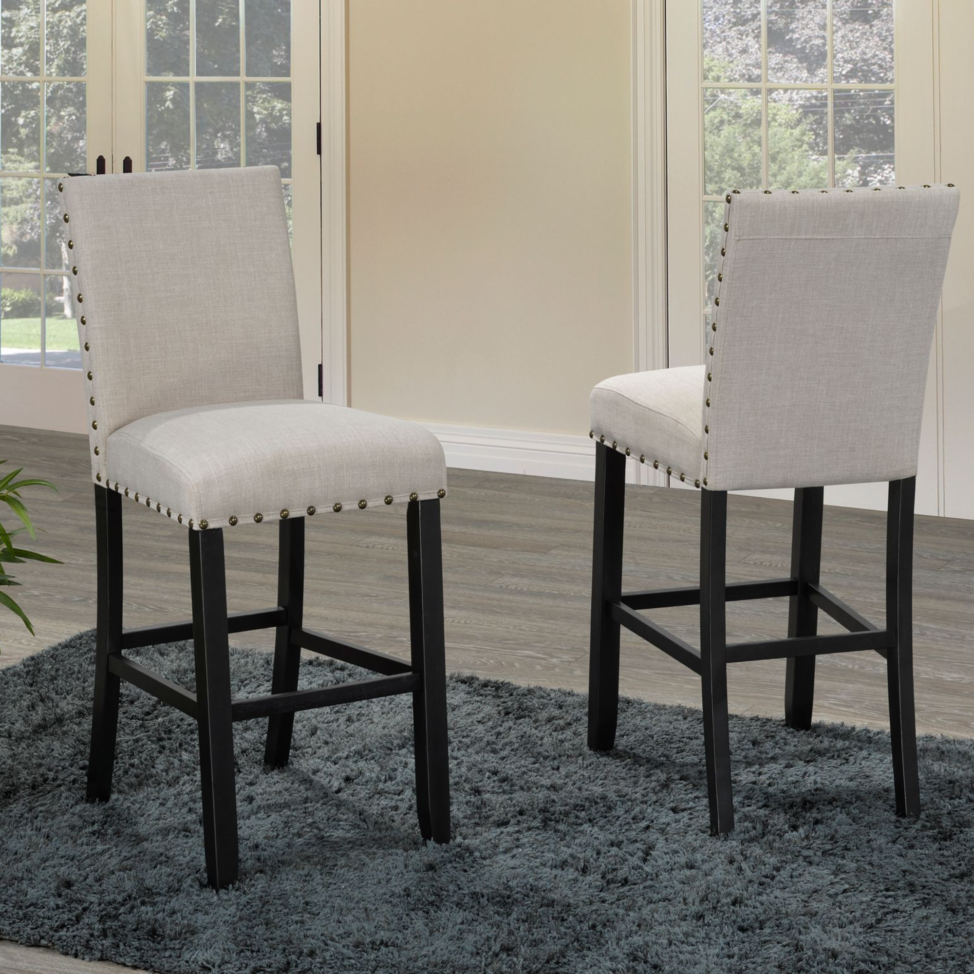 Set of two beige Brassex 29-inch counter bar stools with padded seats and backrests, stylish for kitchen or bar areas.