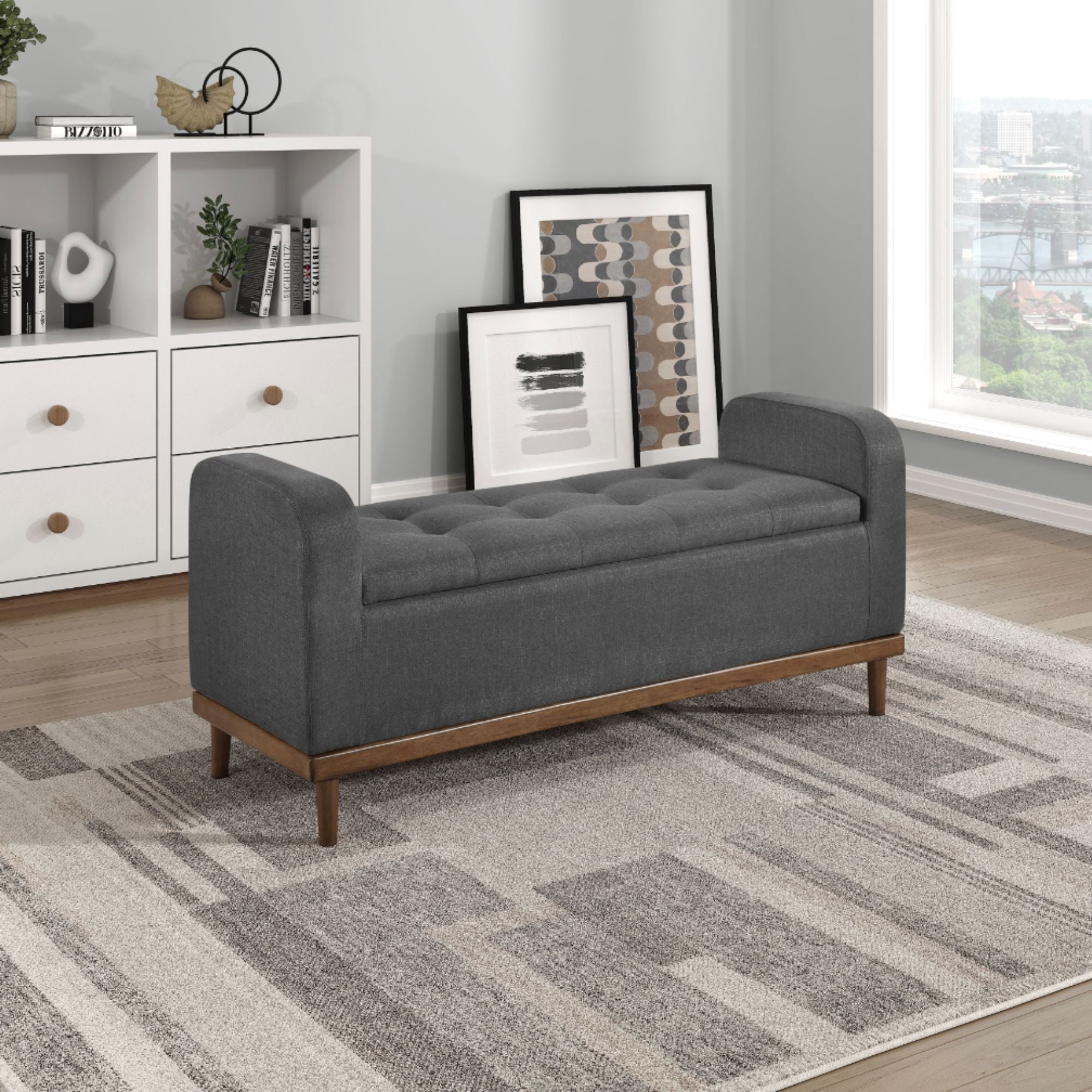 Dark grey MAZ Brigitte Collection lift top storage ottoman with fabric upholstery and spacious interior for versatile storage.