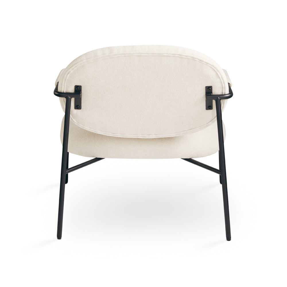 Beige Xcella Alvin accent chair with wooden legs, shown from the back, featuring a plush upholstered seat and stylish design.