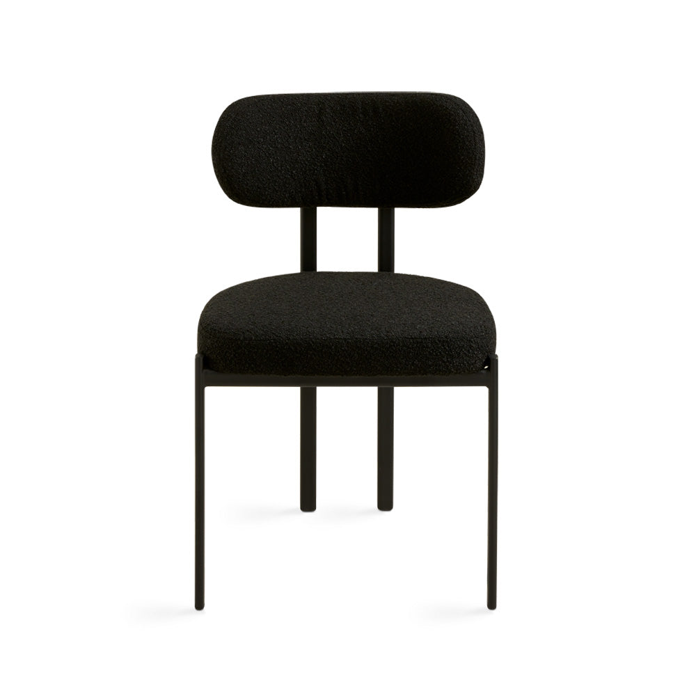 Black boucle Otis dining chair by Xcella with sleek metal legs, showcasing its modern, upholstered design.
